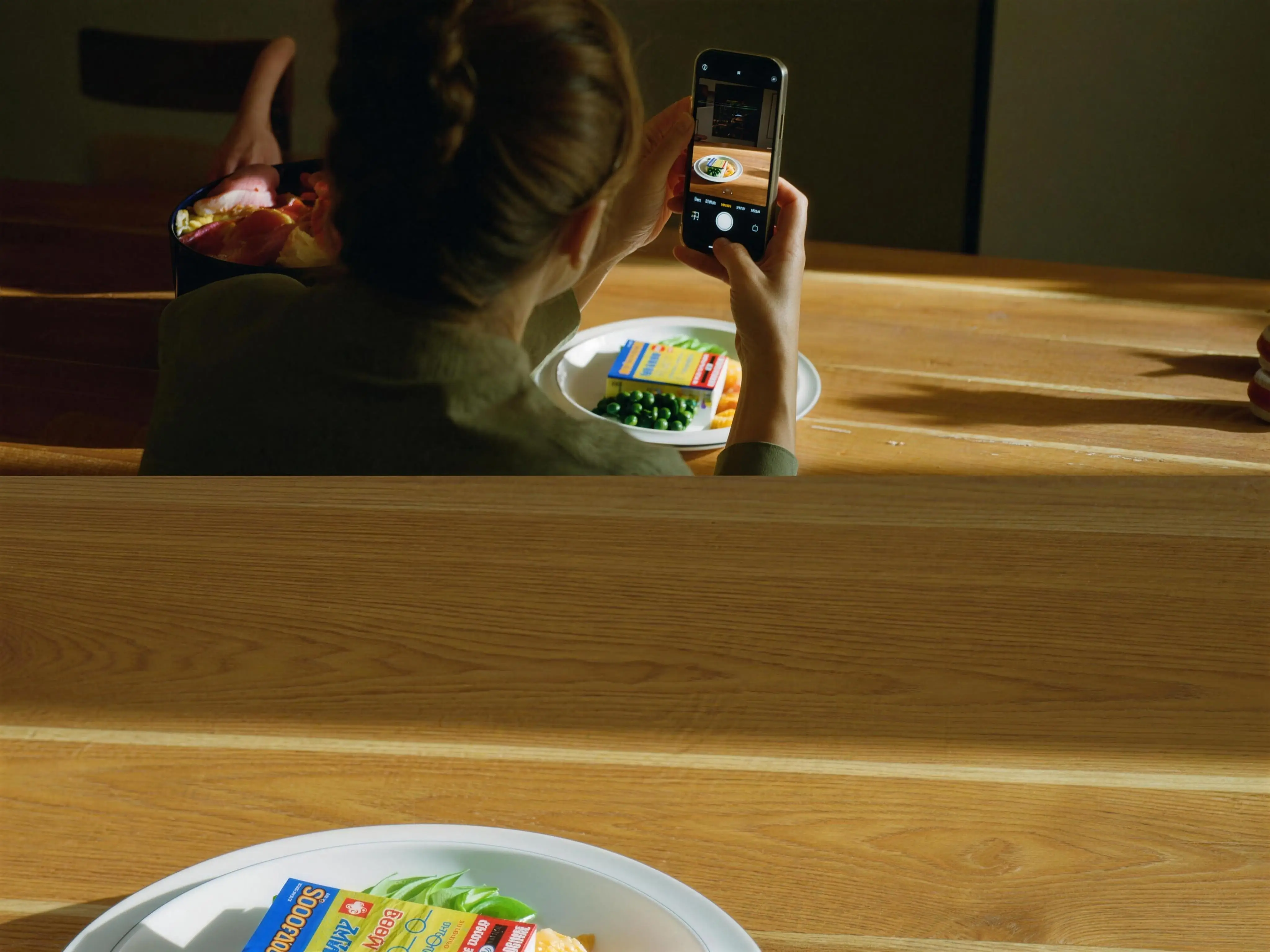A woman photographs her home-cooked plate to log the meal