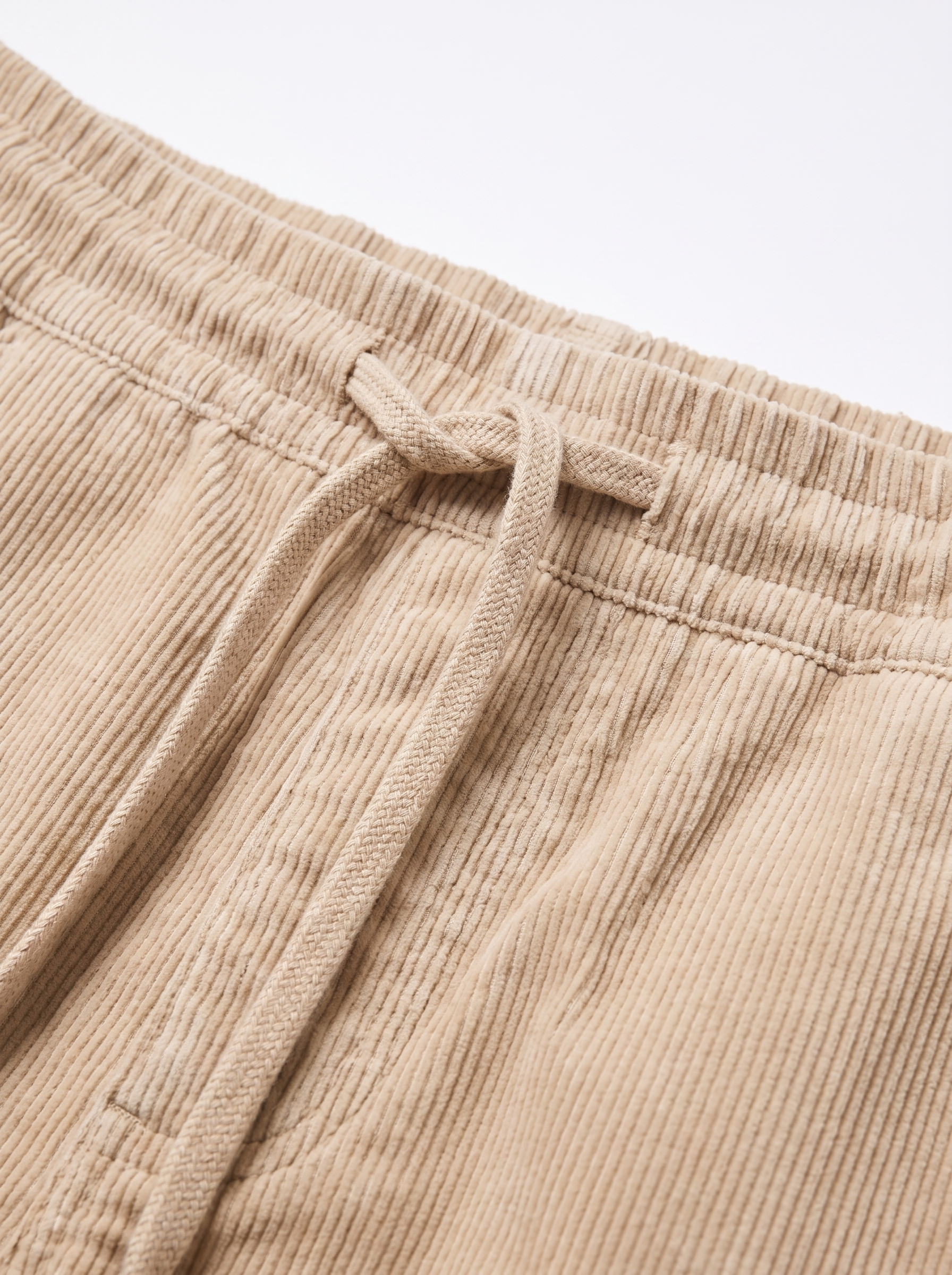 Corduroy pants drawstring waistband and wale texture close up detail