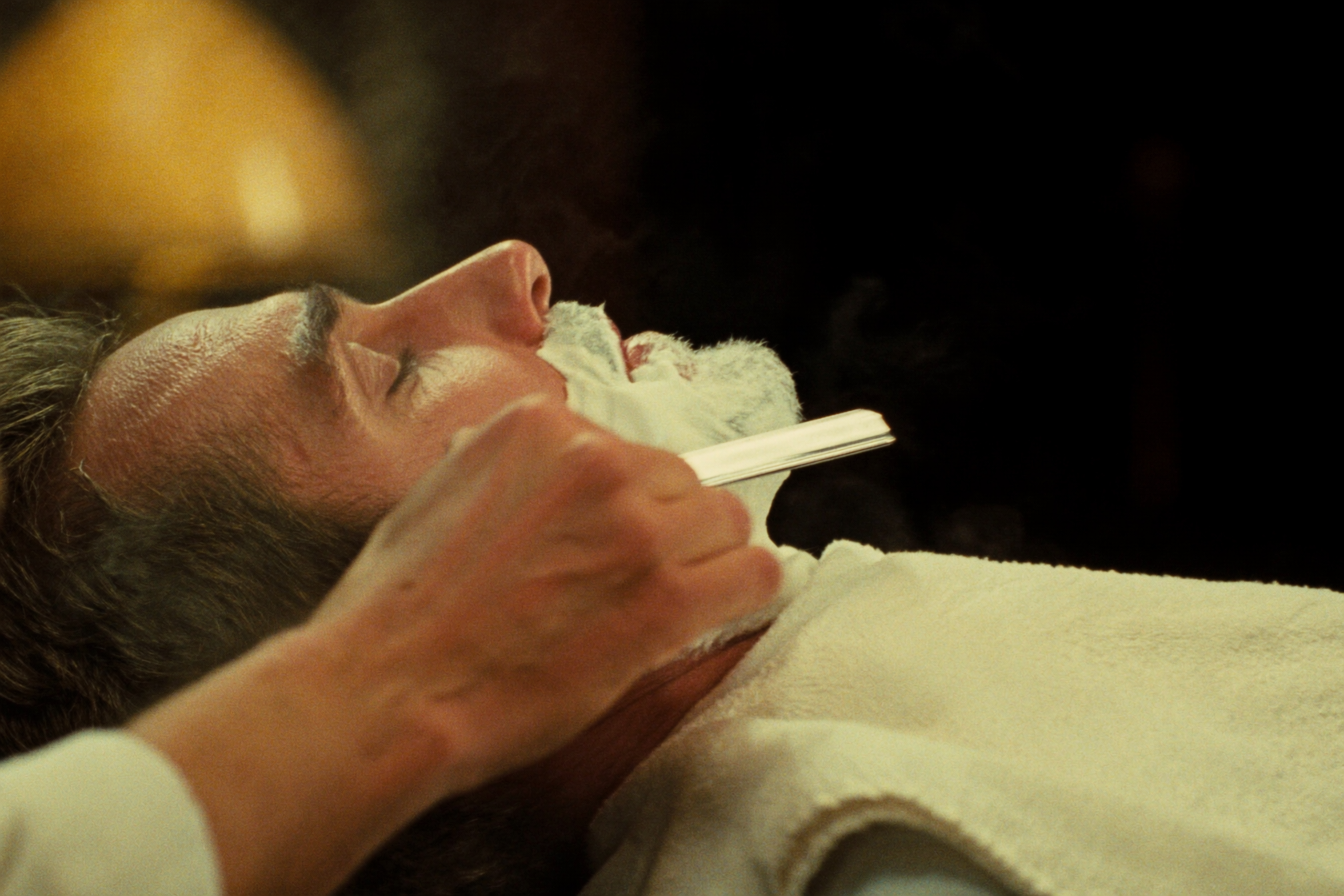Close-up of a straight-razor shave with lather and steam