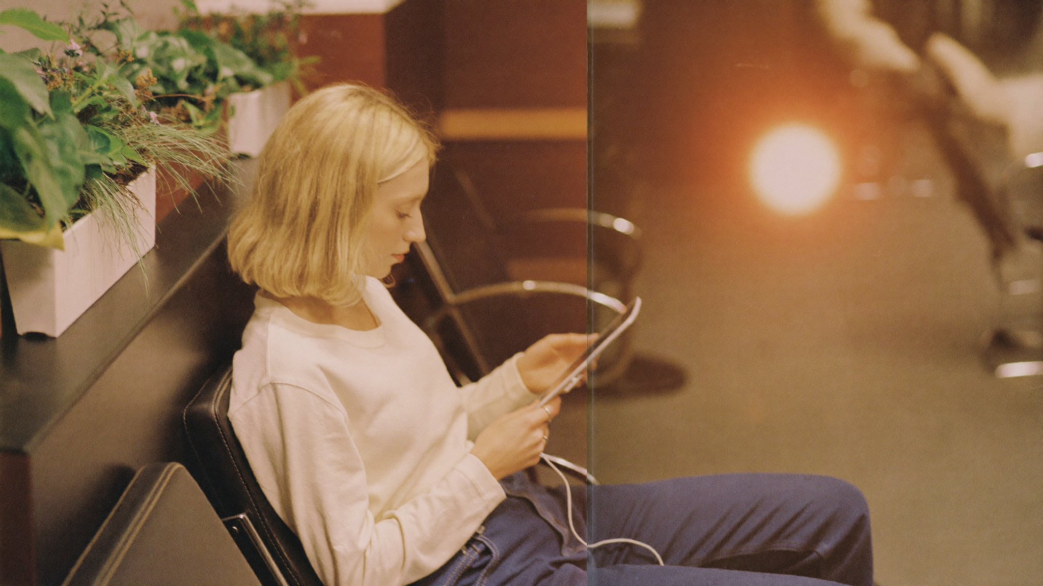 Client checking a phone to confirm a salon appointment in a bright waiting area