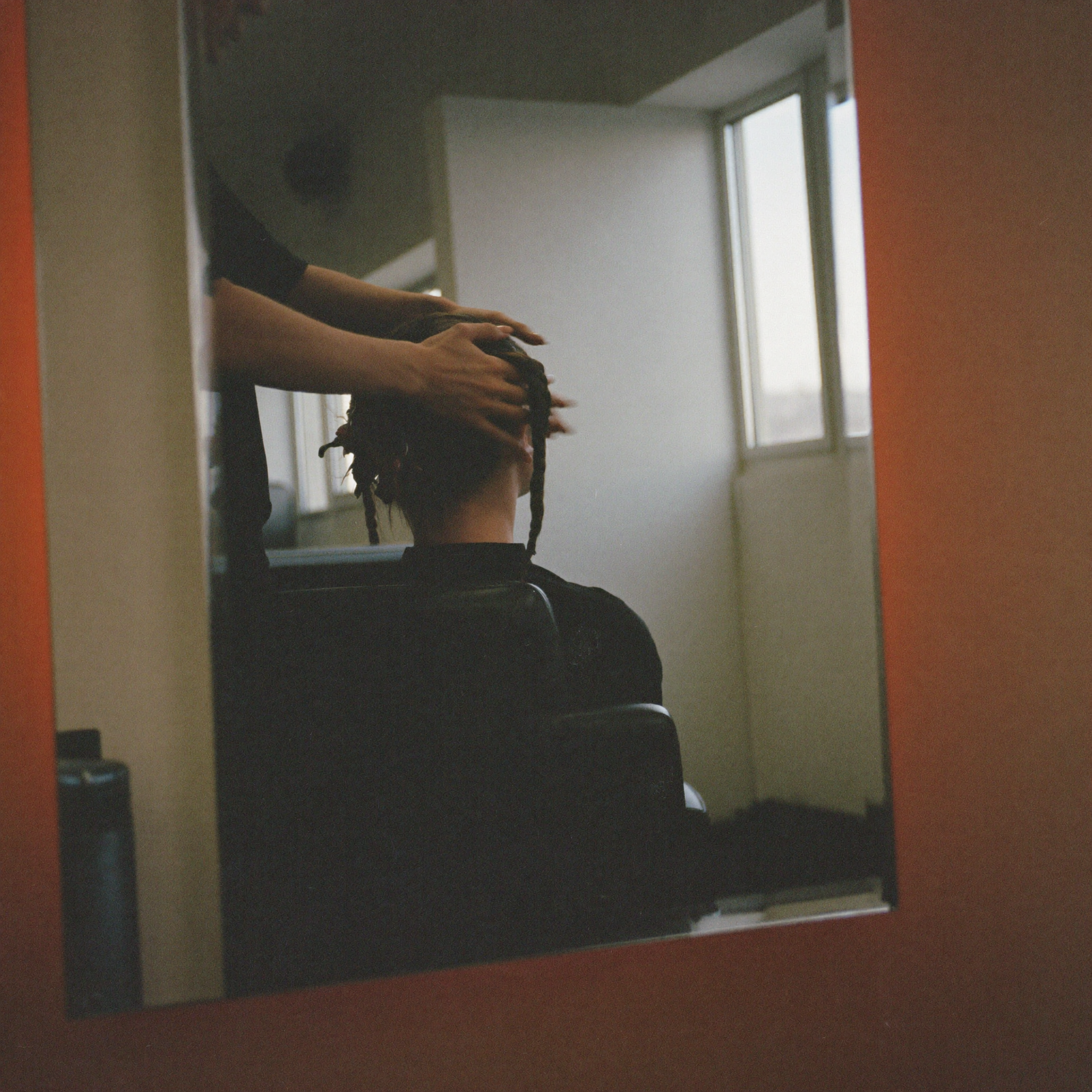 Hairstylist working through a client's hair in a salon chair