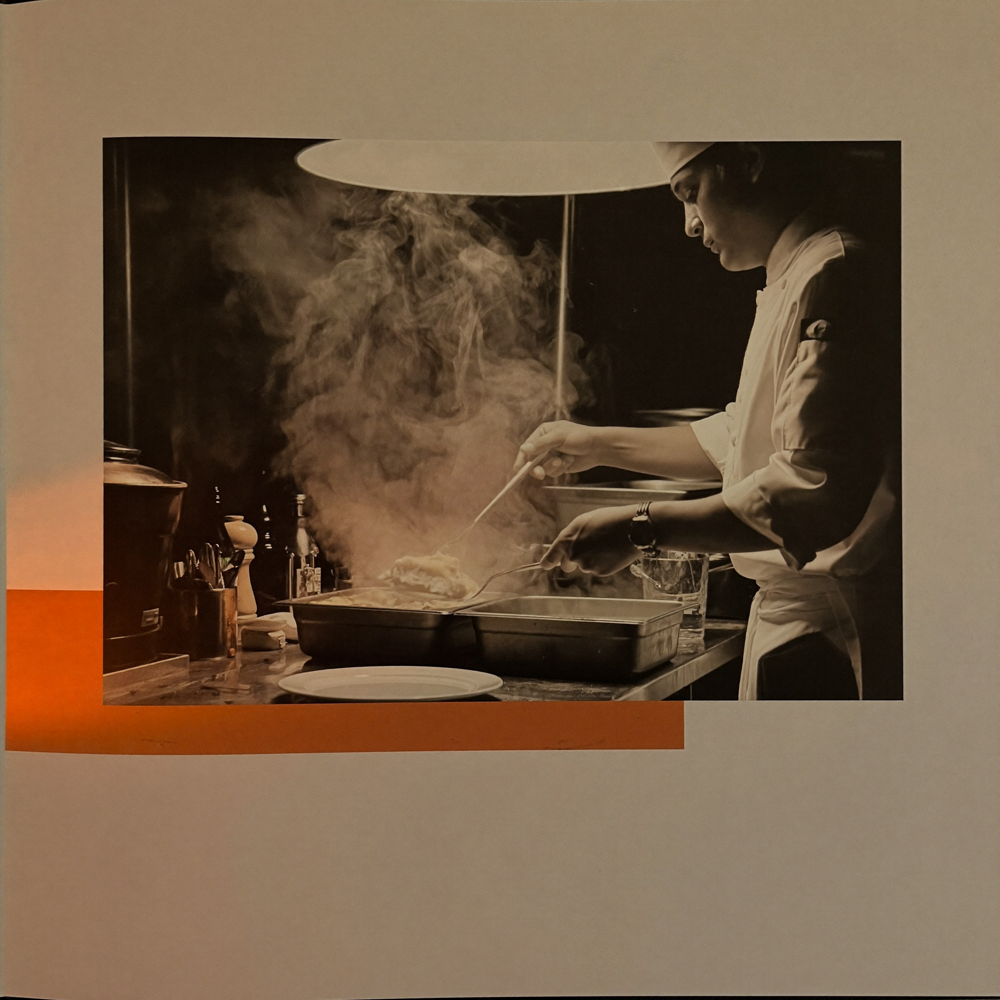 Chef plating a dish in an open restaurant kitchen with steam rising