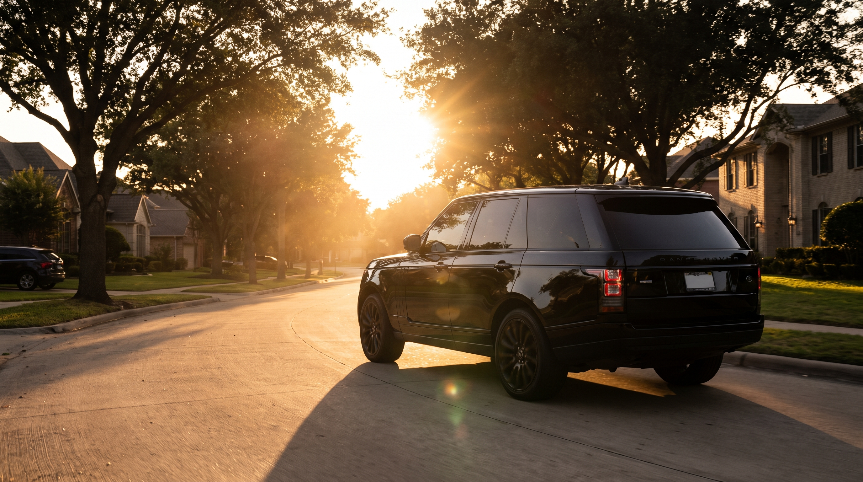 SUV negra con ventanas polarizadas en carretera al atardecer
