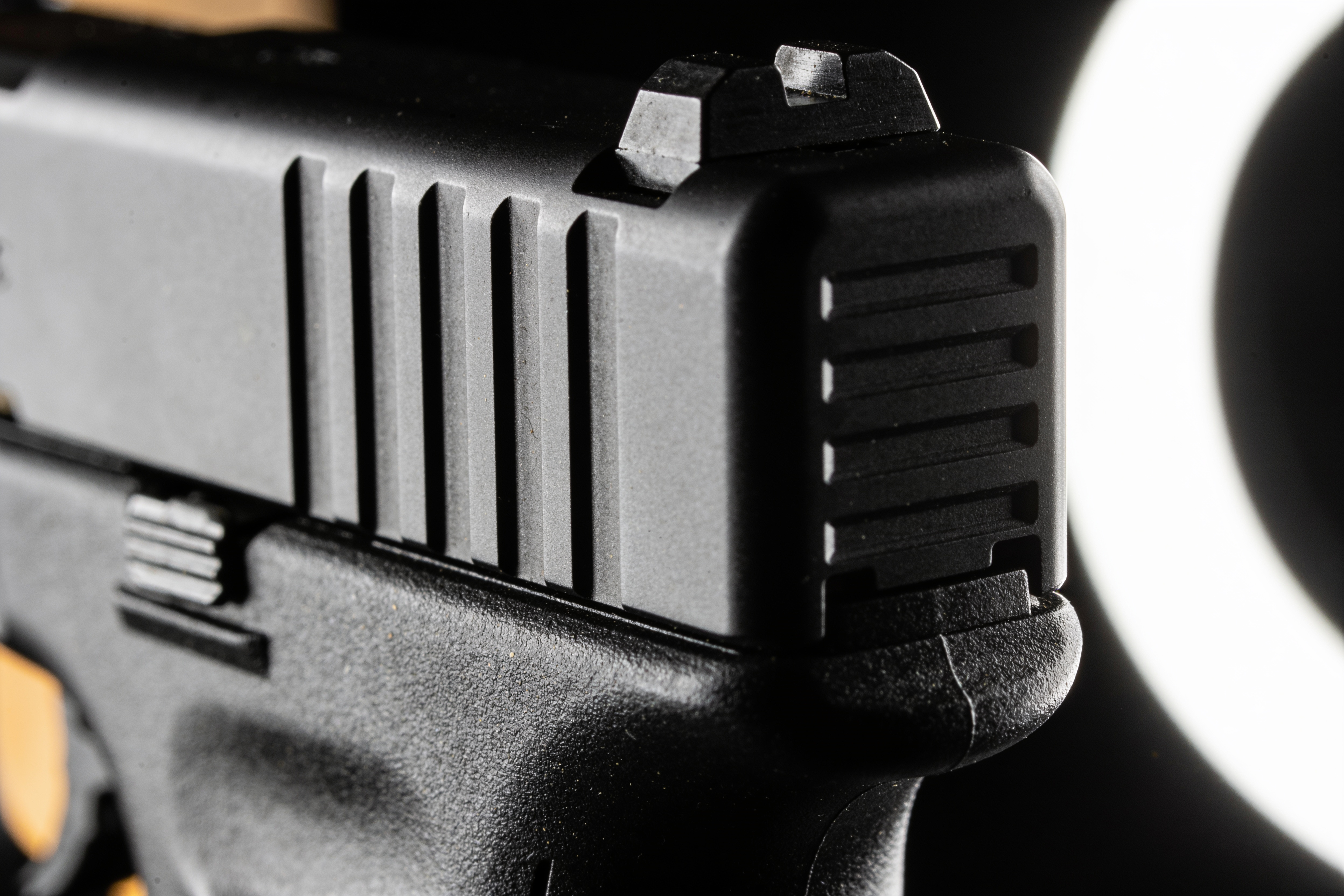 Macro detail of pistol slide serrations in low light