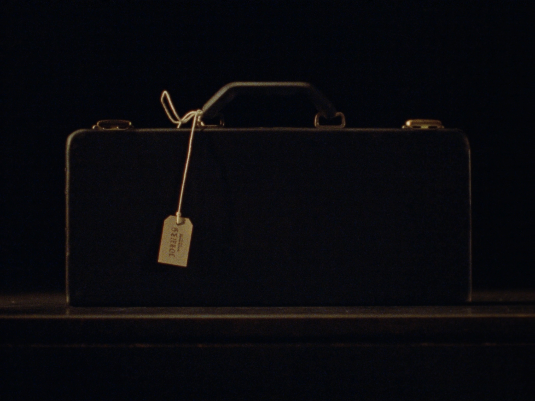 Closed rifle hard case with a kraft paper inventory tag on a dark counter
