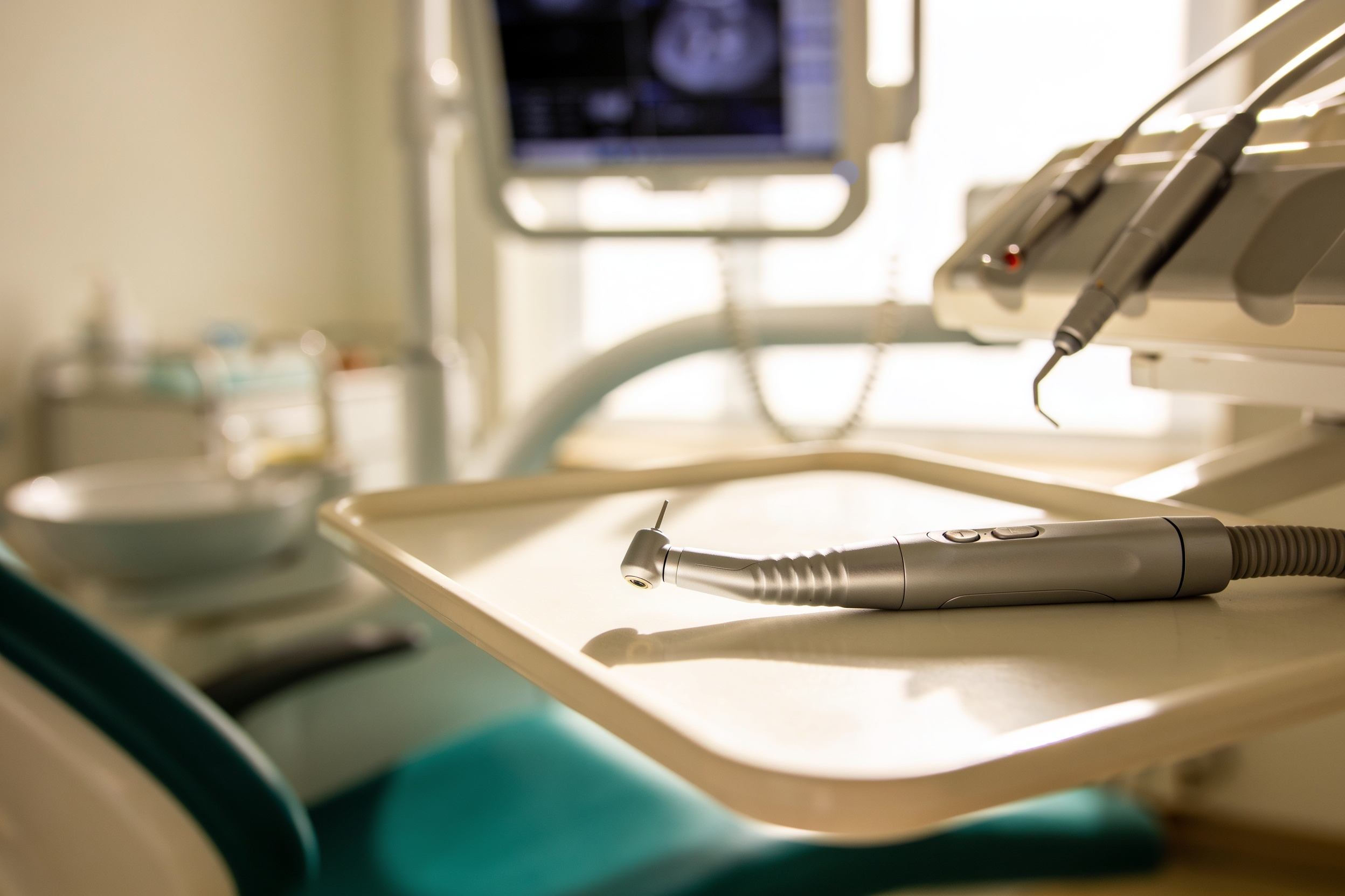 An intraoral scanner resting on a tray in a surgery