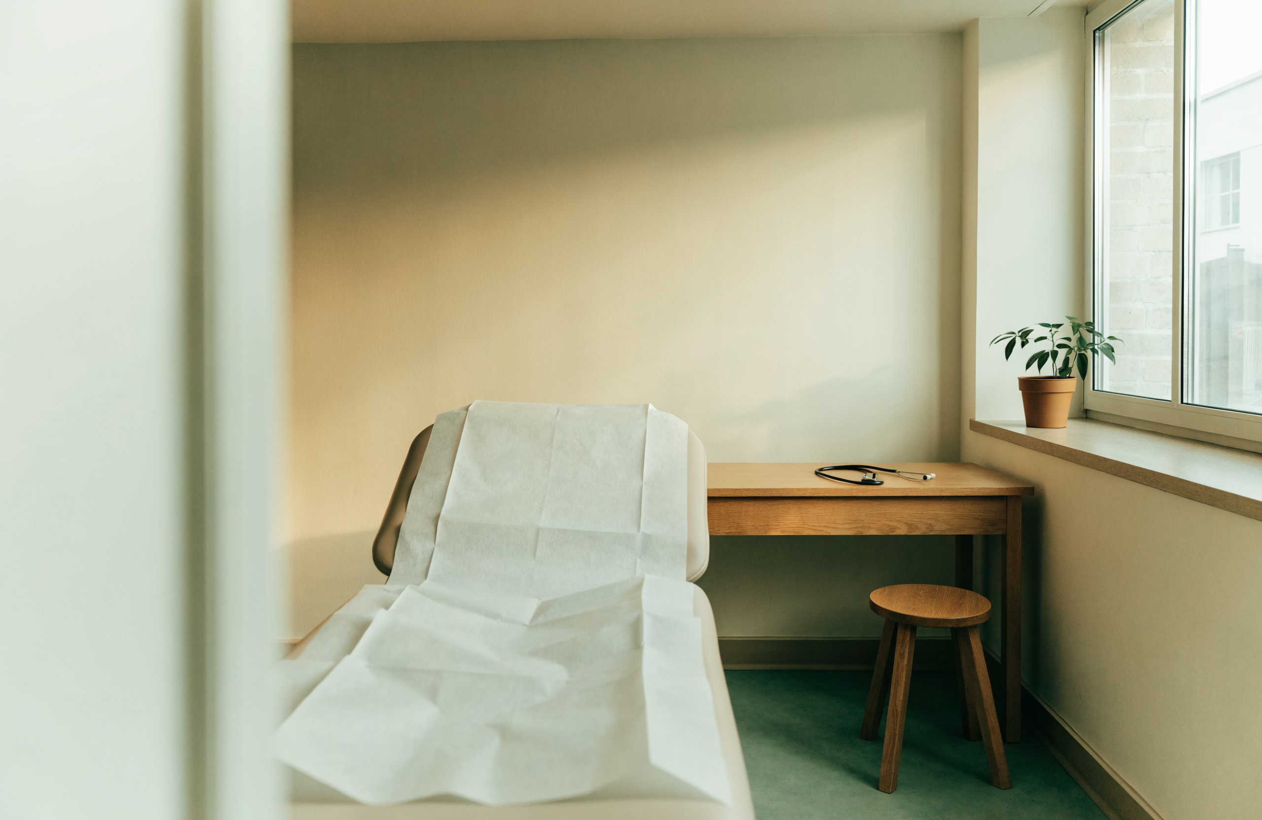 A quiet exam room with a treatment table and window light