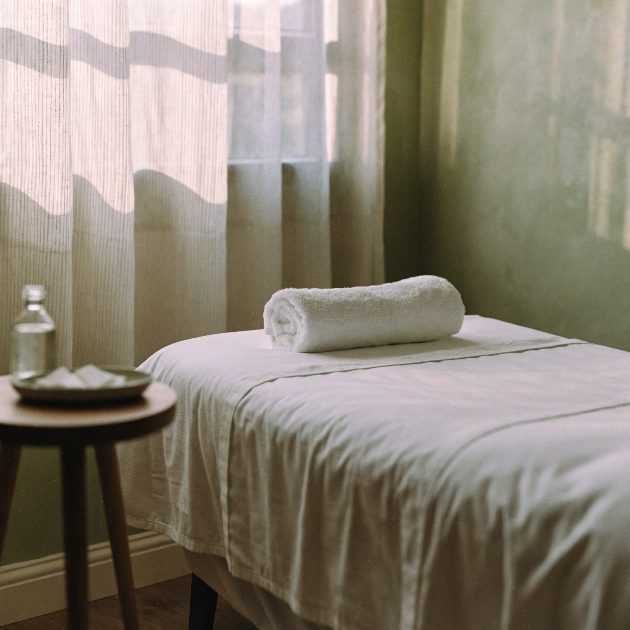 A facial treatment bed made up with fresh linens