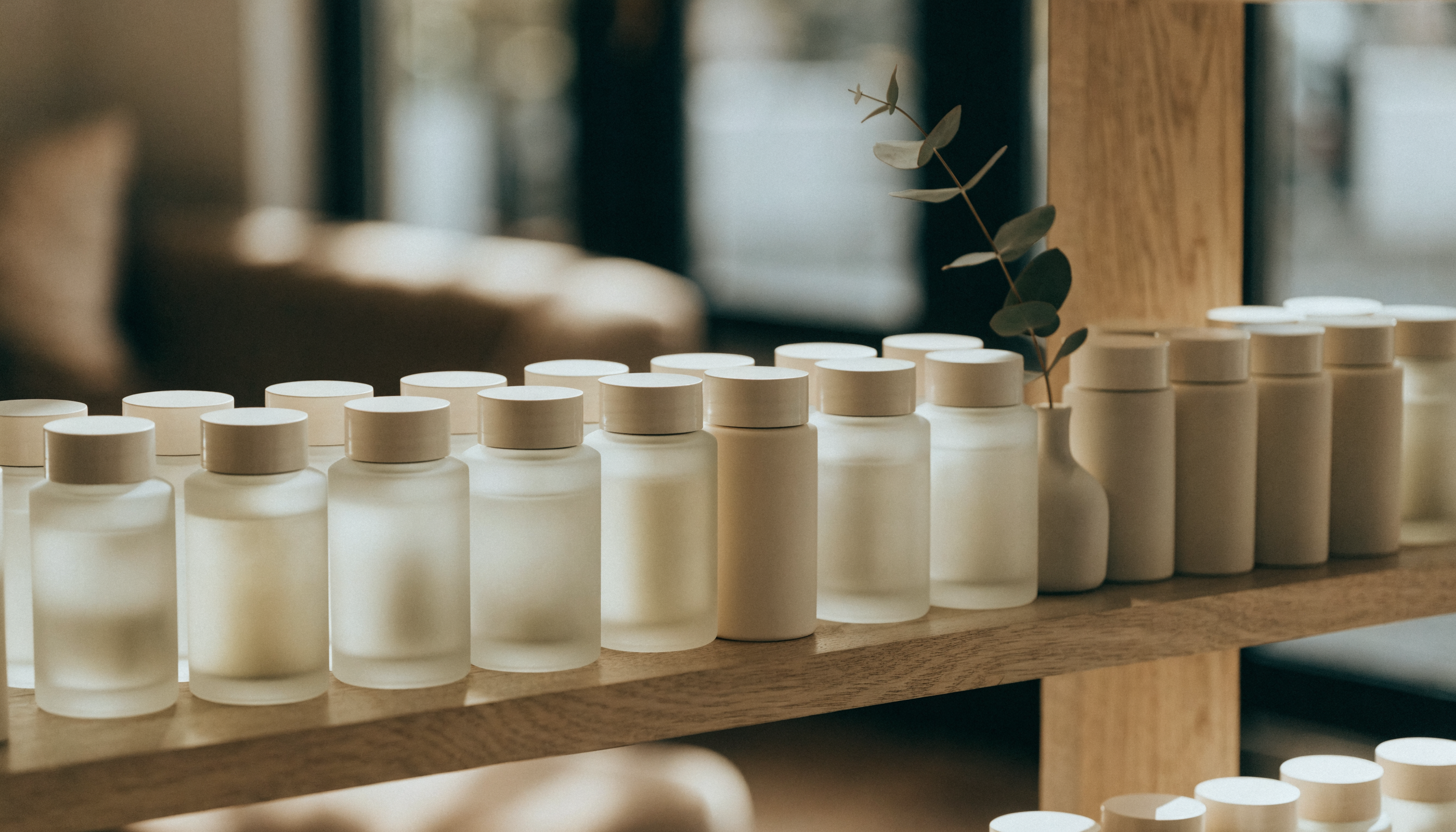 A shelf of unlabeled skincare bottles and jars