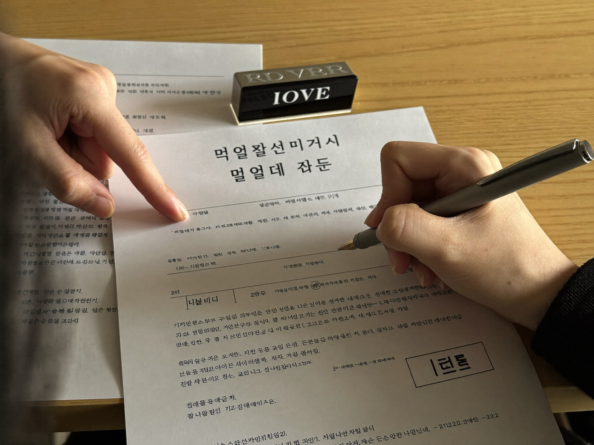 변호사 사무실에서 위임계약서의 보수 조항을 확인하며 서명하는 모습