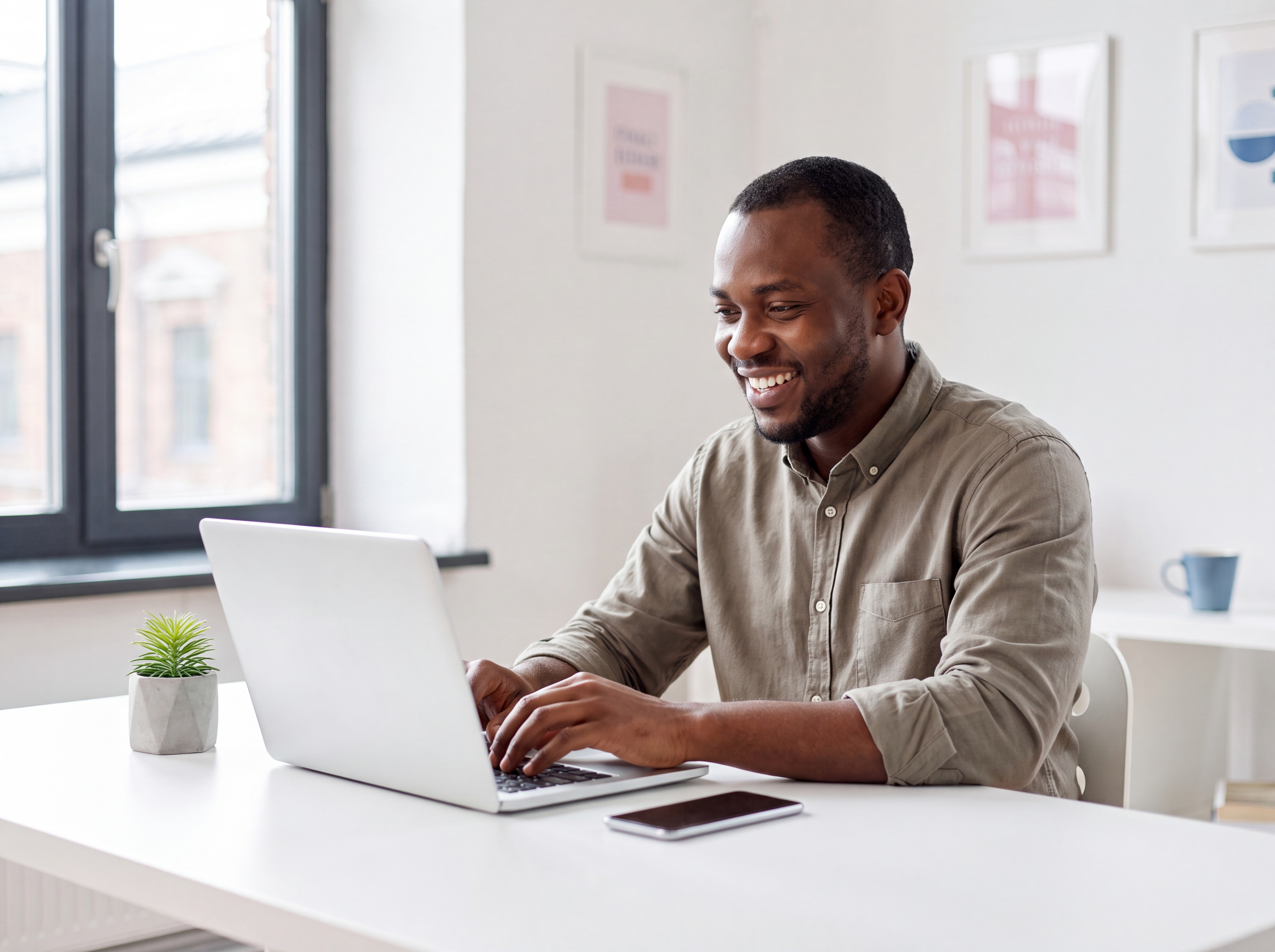 Nigerian business owner working on his website at a bright desk