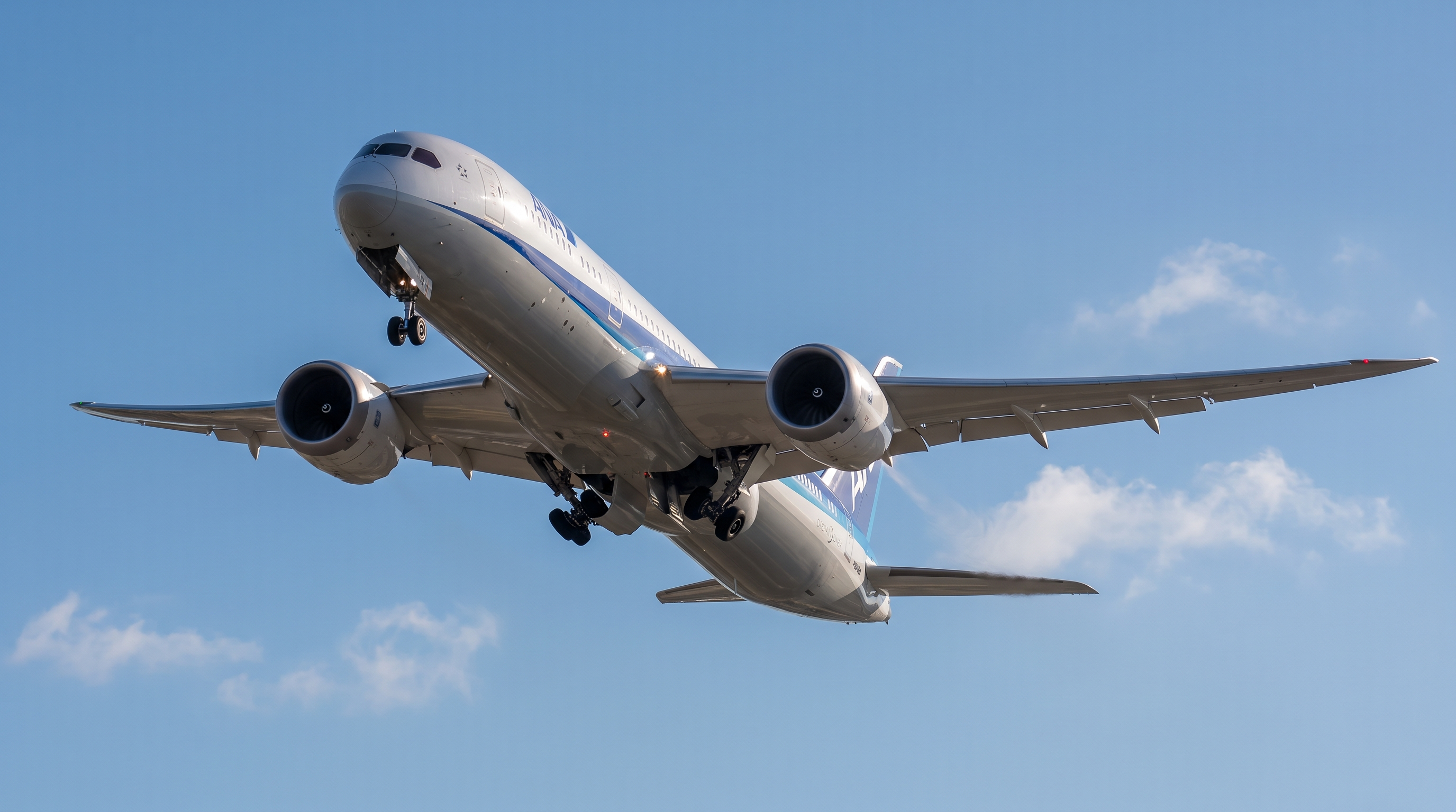 A large passenger airliner climbing into a blue sky with wings and engines visible