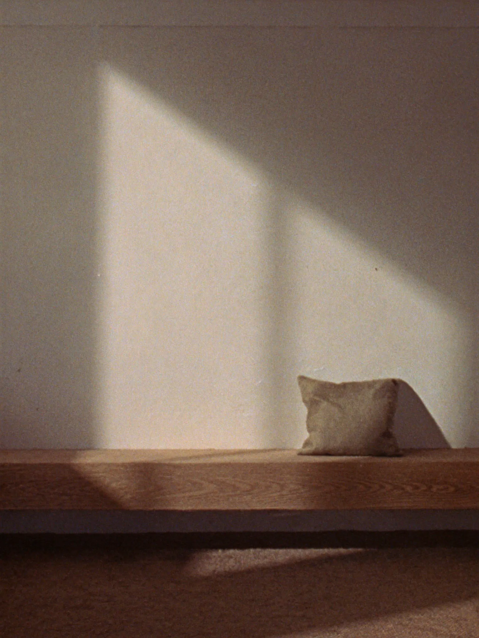 Limewash wall and oak bench in window light