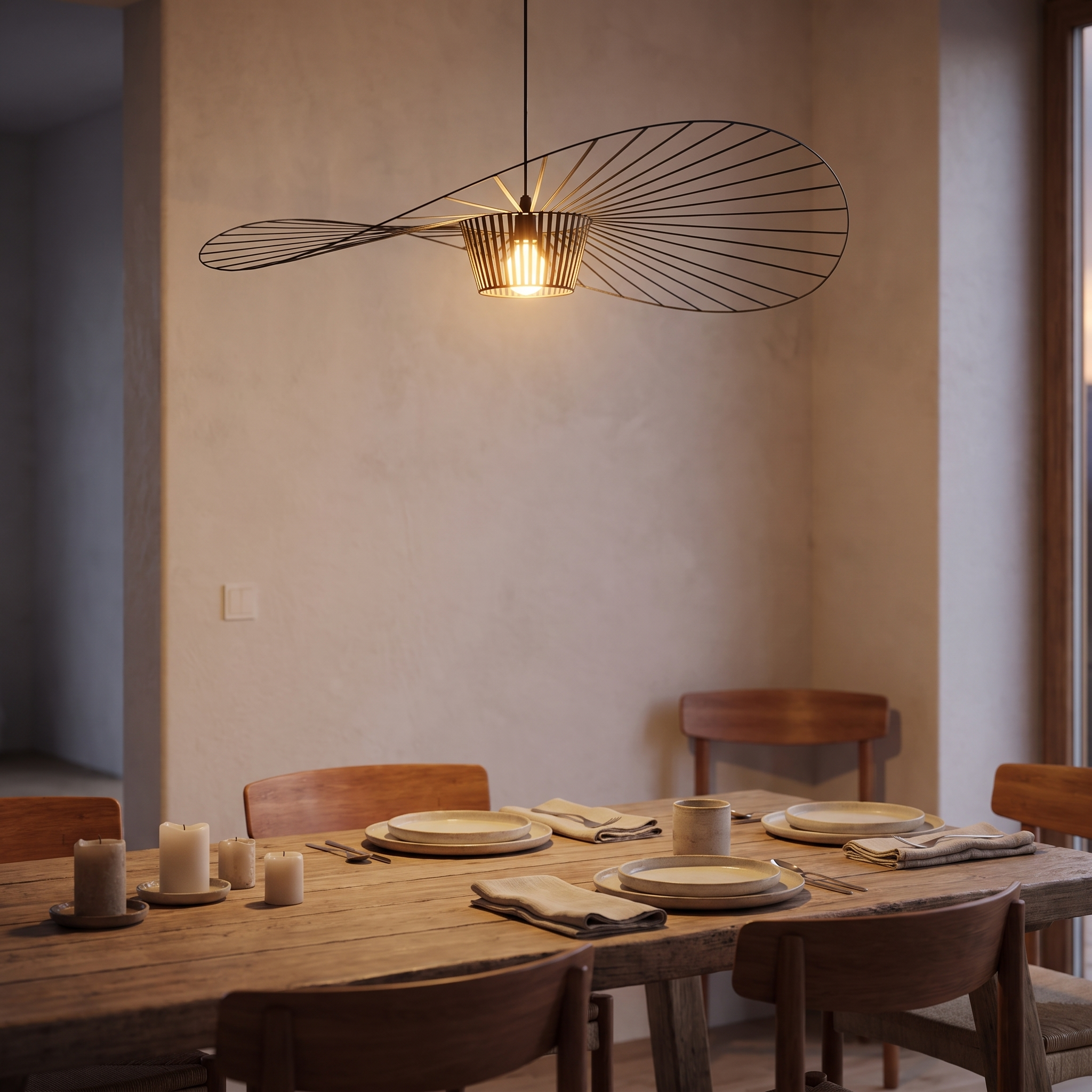Metalen hanglamp met brede kap boven een houten eettafel in de avond
