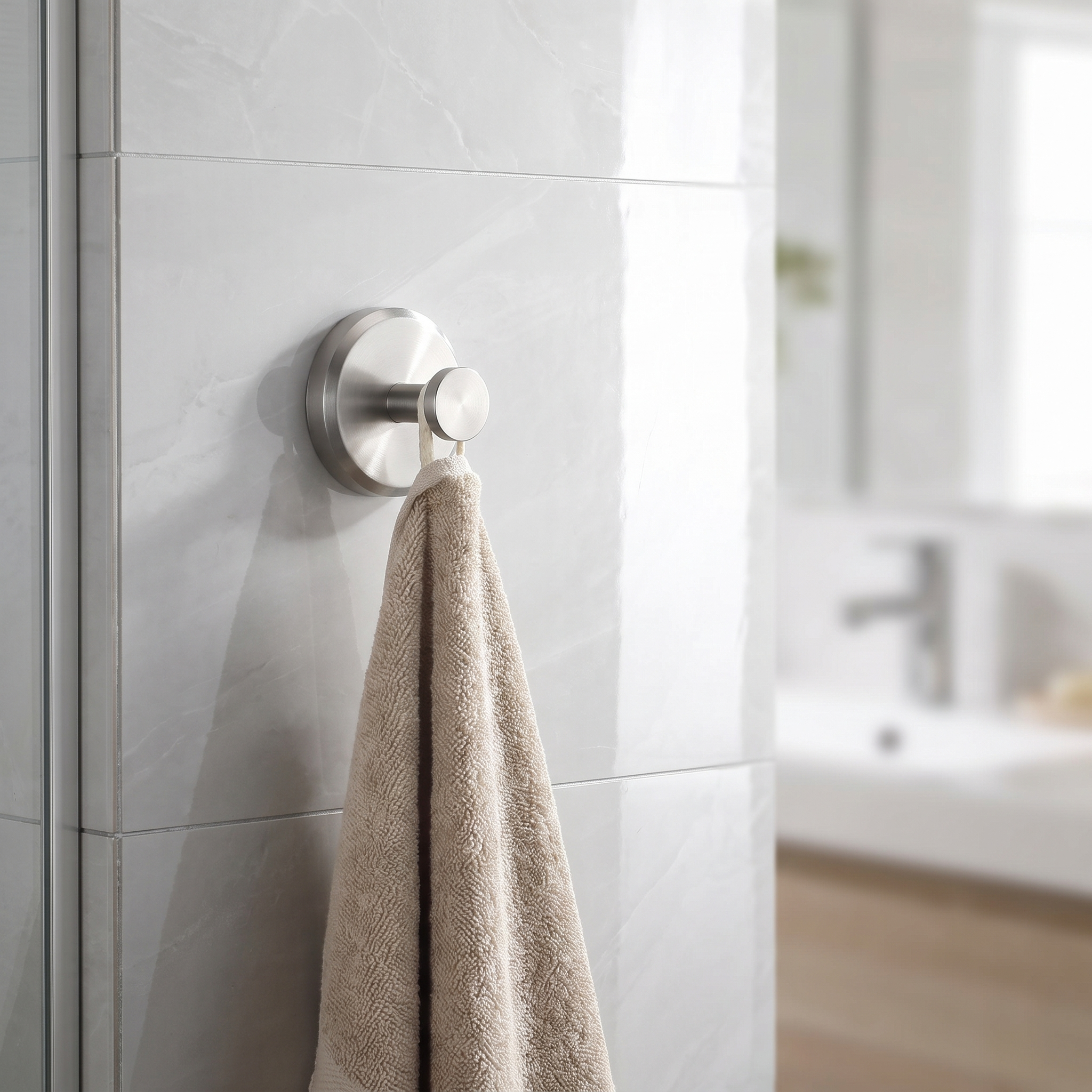 Towel hook on a tiled bathroom wall with a towel