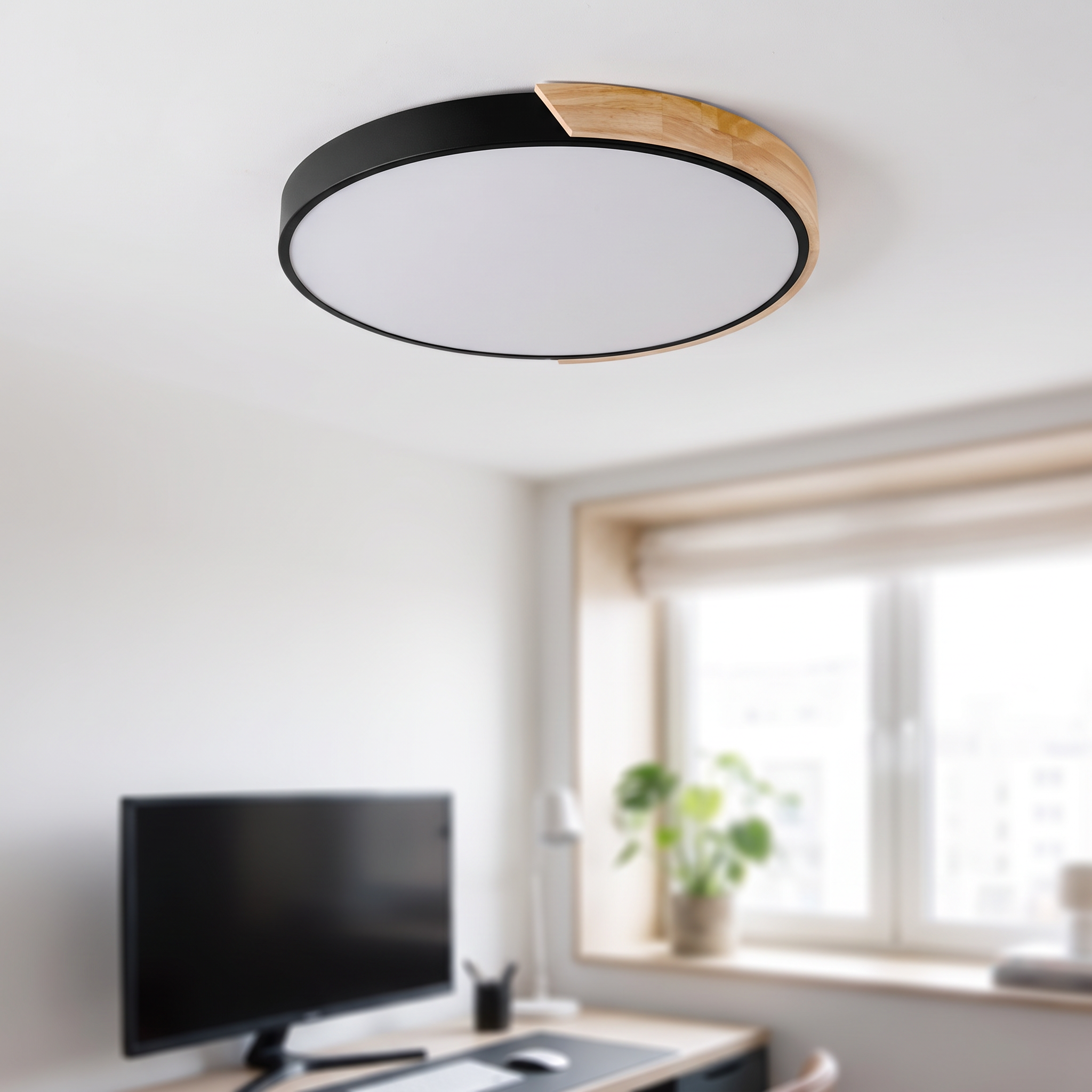 Schwarze runde Macaron-Deckenlampe mit 30 cm Durchmesser über einem Schreibtisch