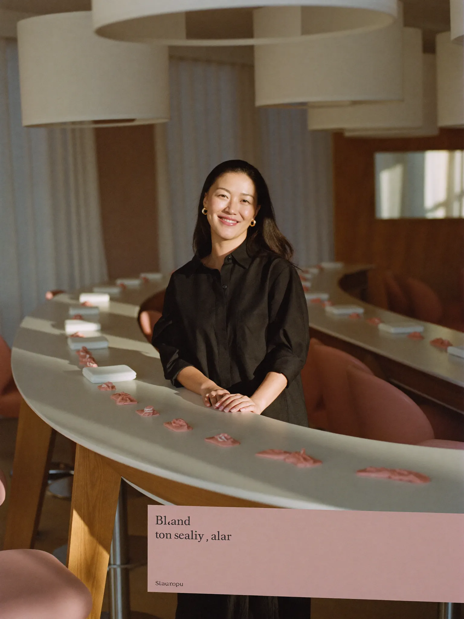 Owner of a modern nail and beauty salon beside a row of stations