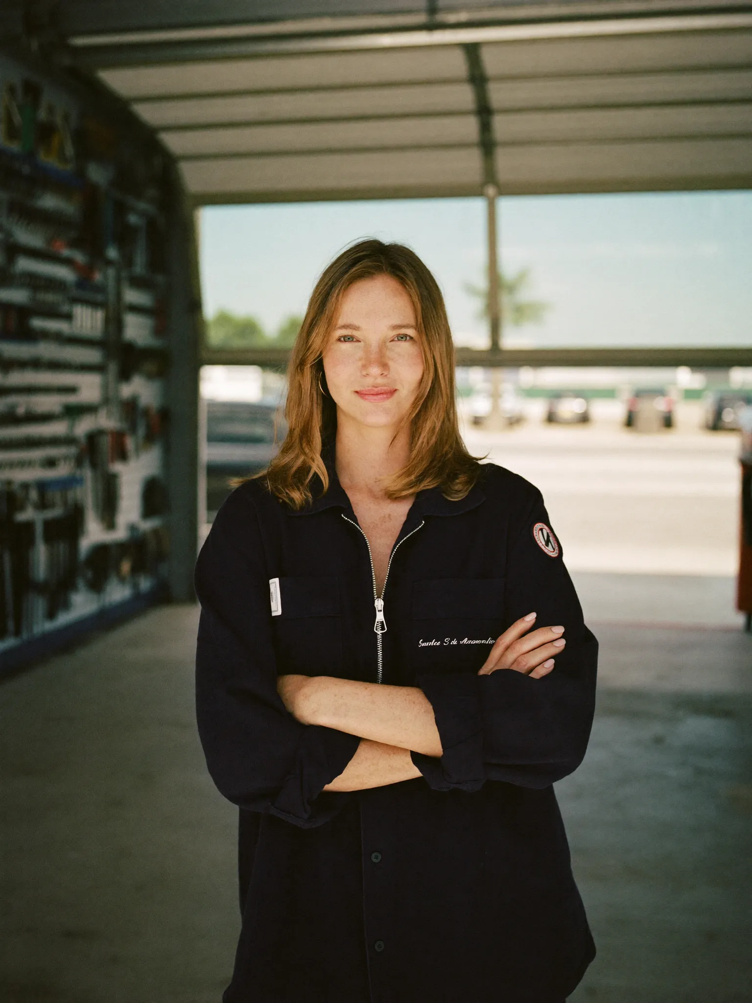 Owner of an independent auto repair shop standing in an open garage bay