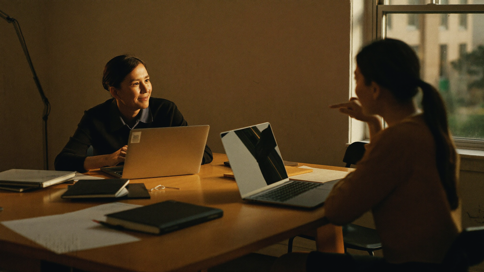 Two colleagues in conversation at a shared table