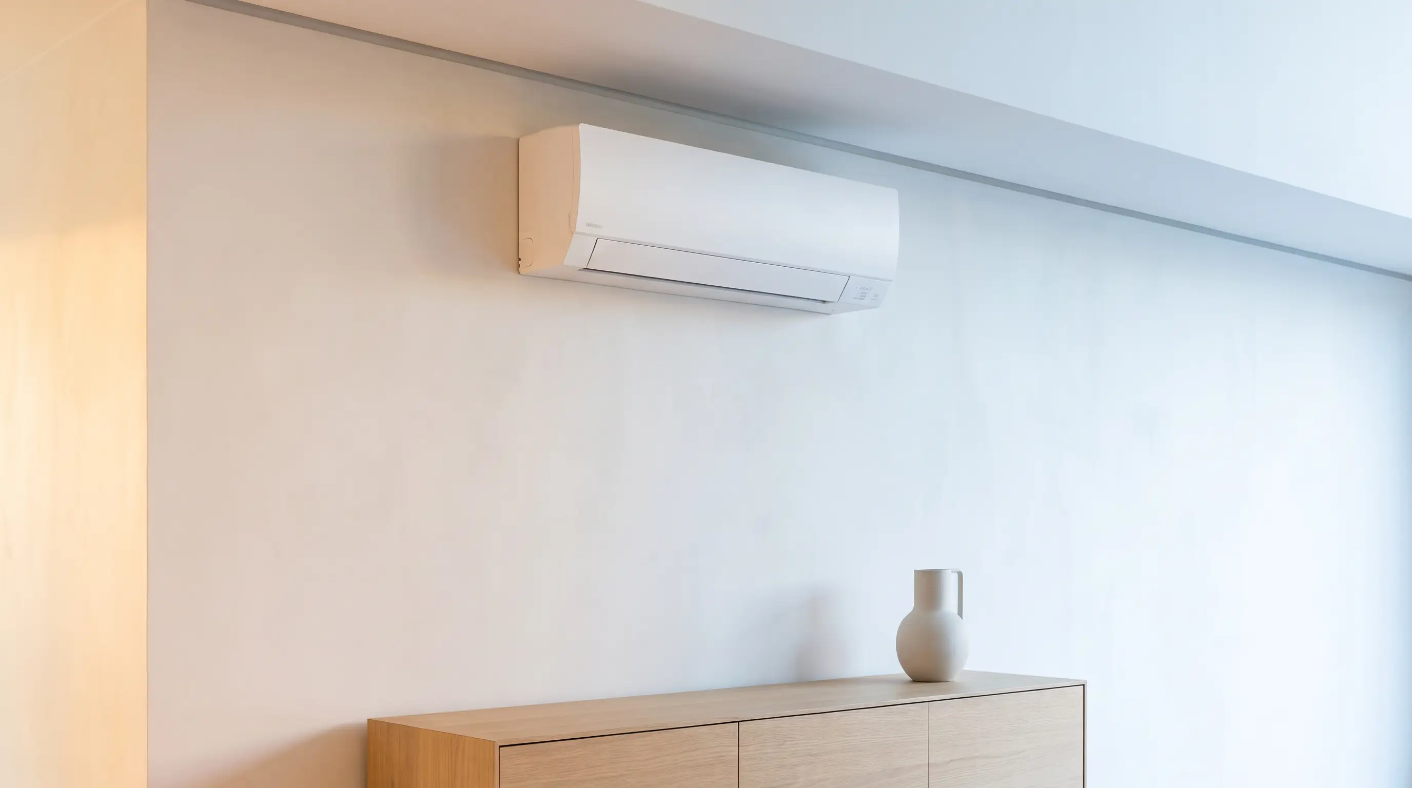 Slim white wall-mounted unit installed just below the ceiling above an oak sideboard