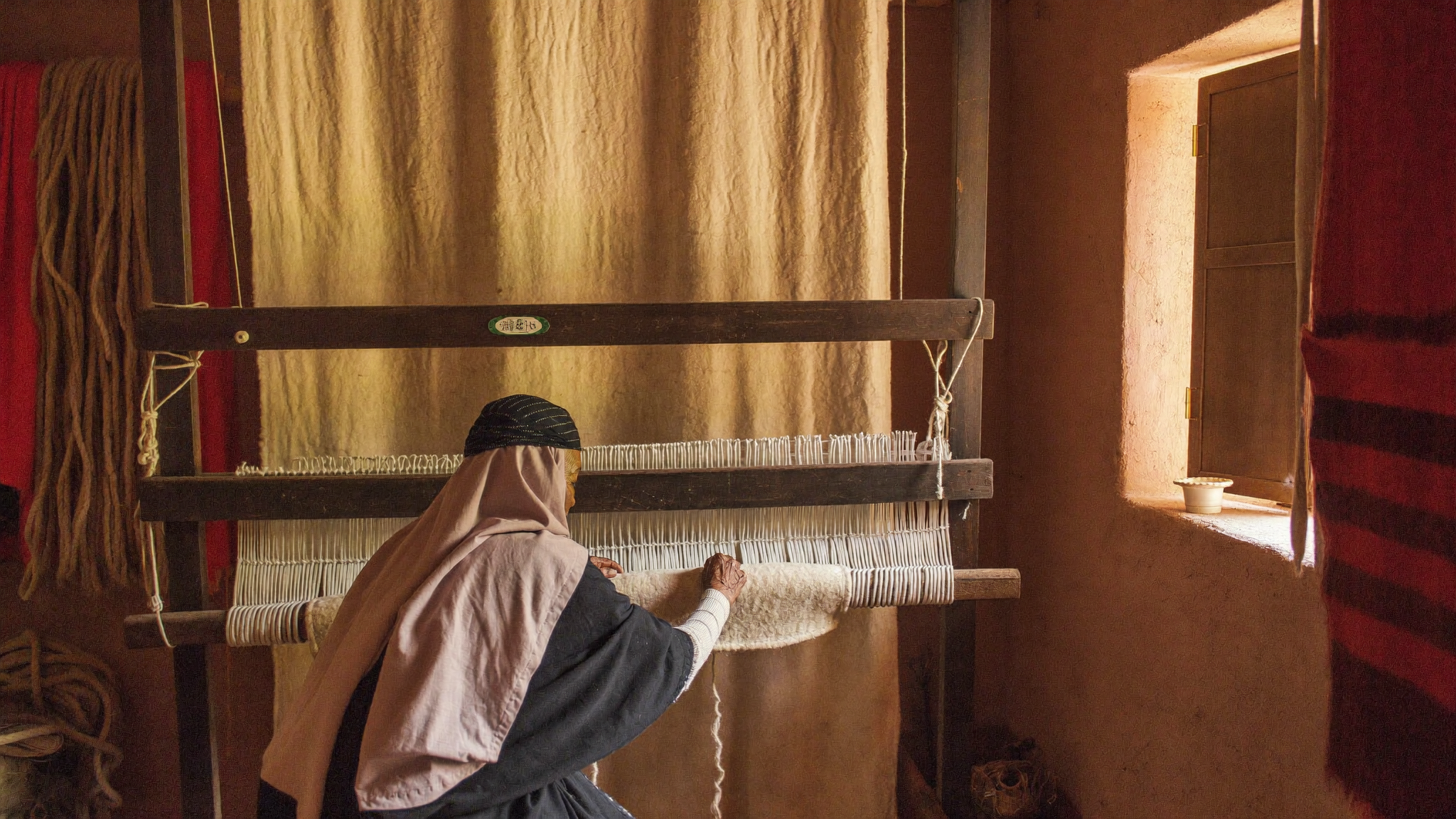 Tisseuse berbère au métier à tisser dans l'Atlas