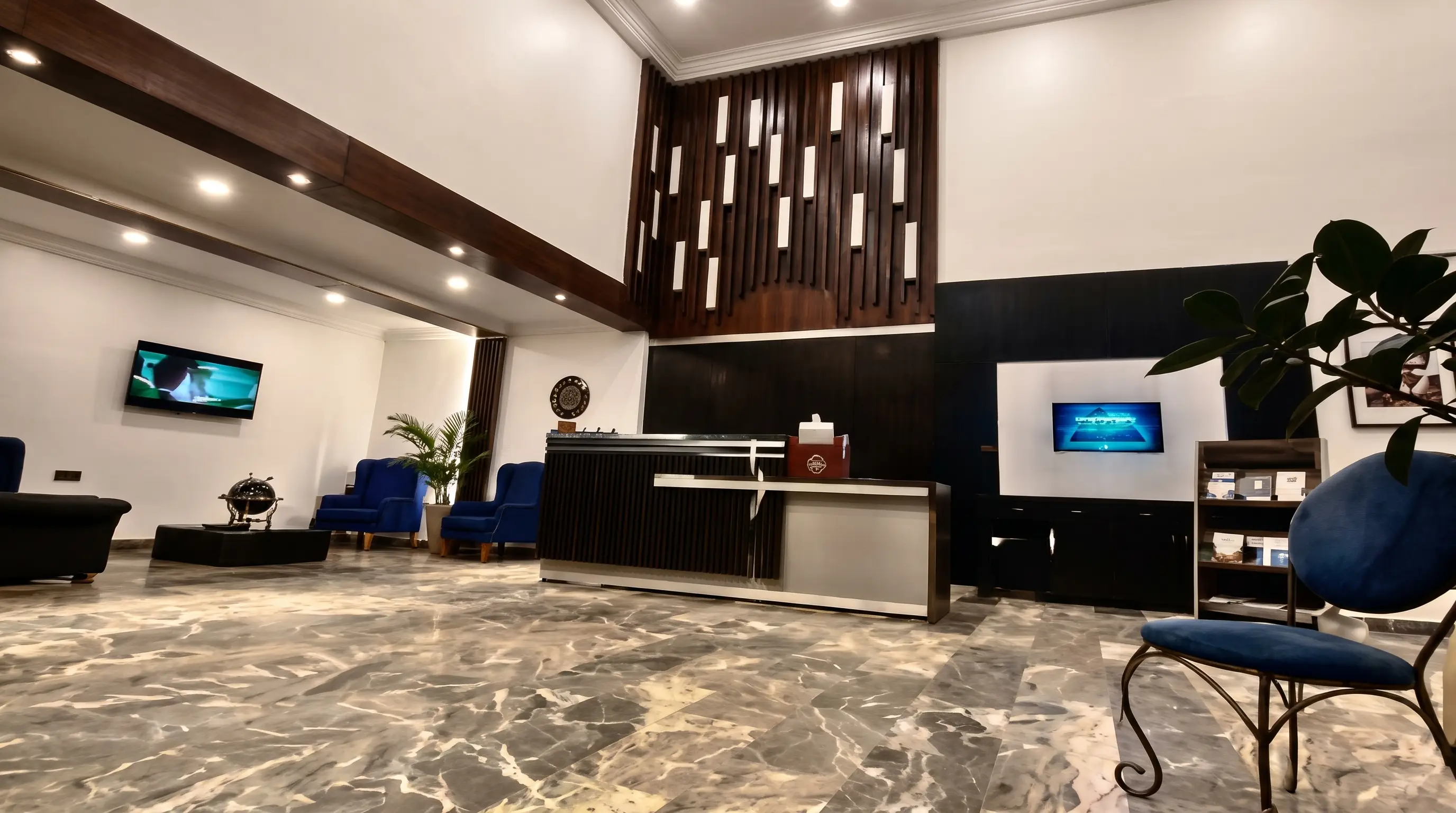 The lobby atrium and curved marble staircase at OVIC Hotel