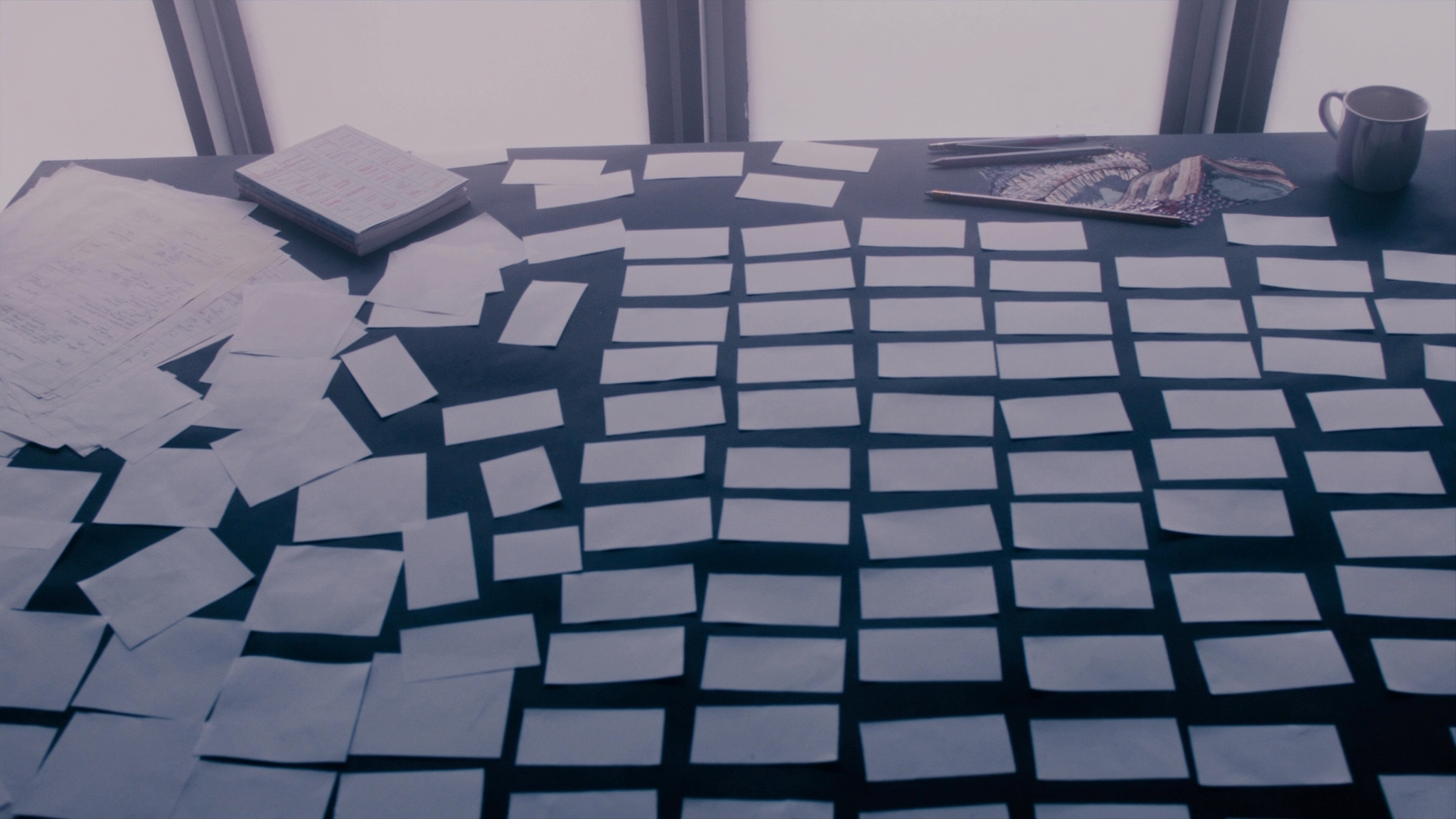 Overhead view of a workshop table covered in blank index cards at the end of a session