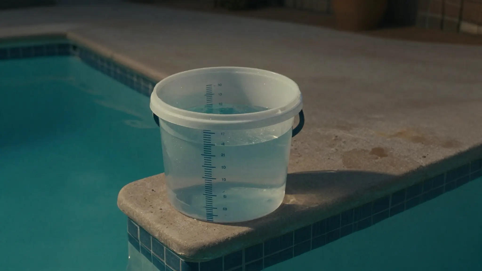 DIY pool leak testing — a bucket test set up on the pool steps