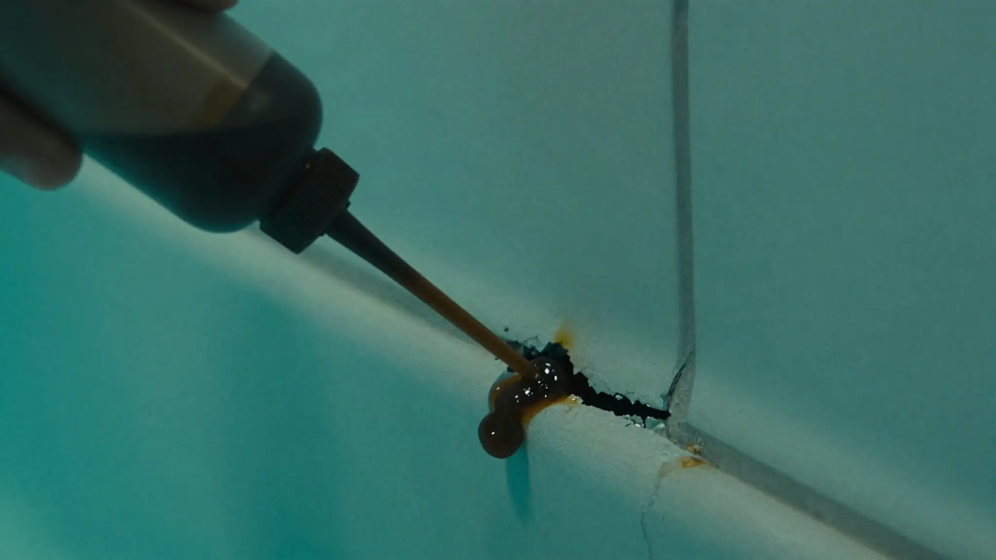 doing a dye test for a pool leak — dye pulled toward a crack in the pool wall