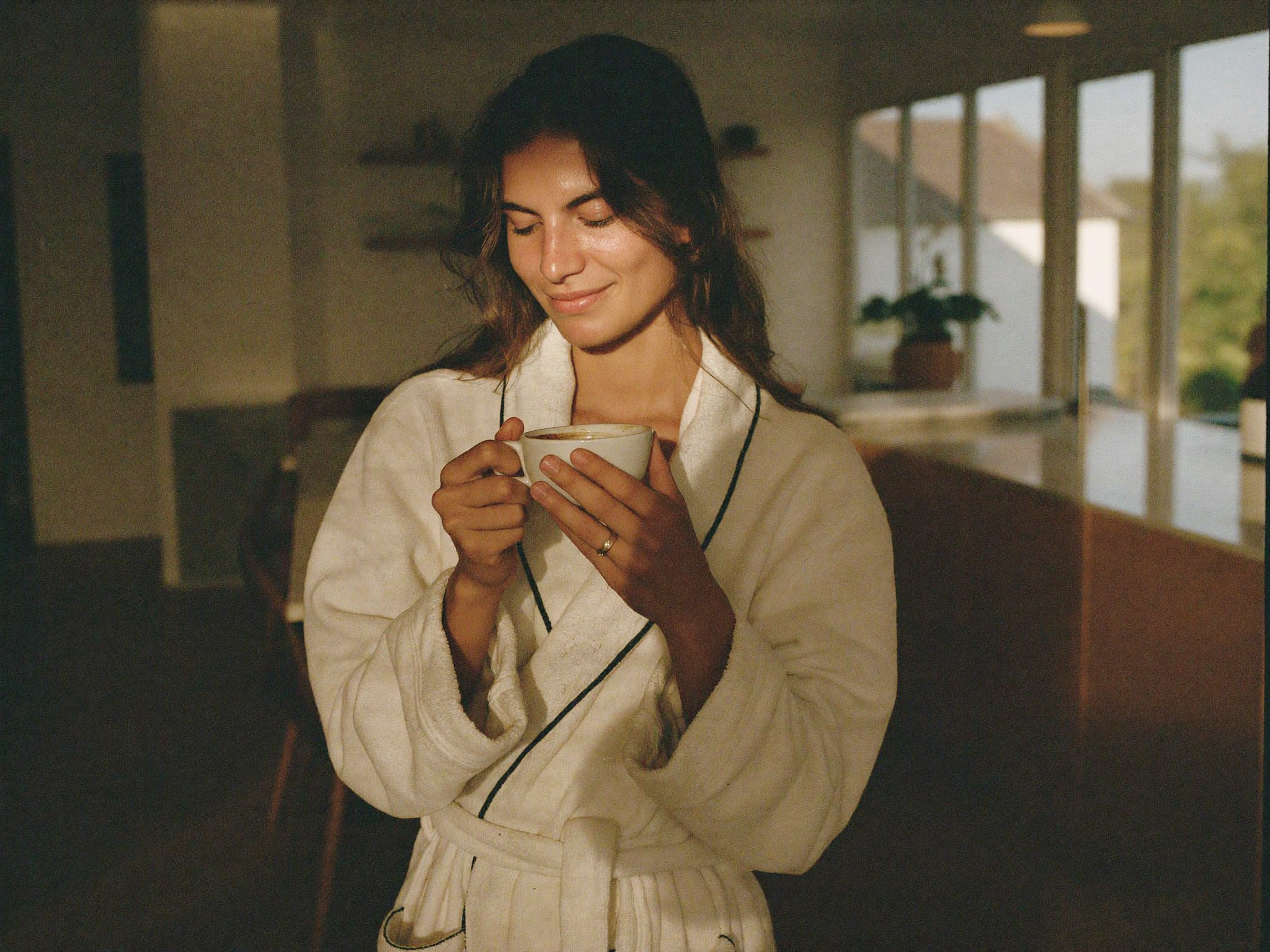 Personne détendue en peignoir avec un café le matin