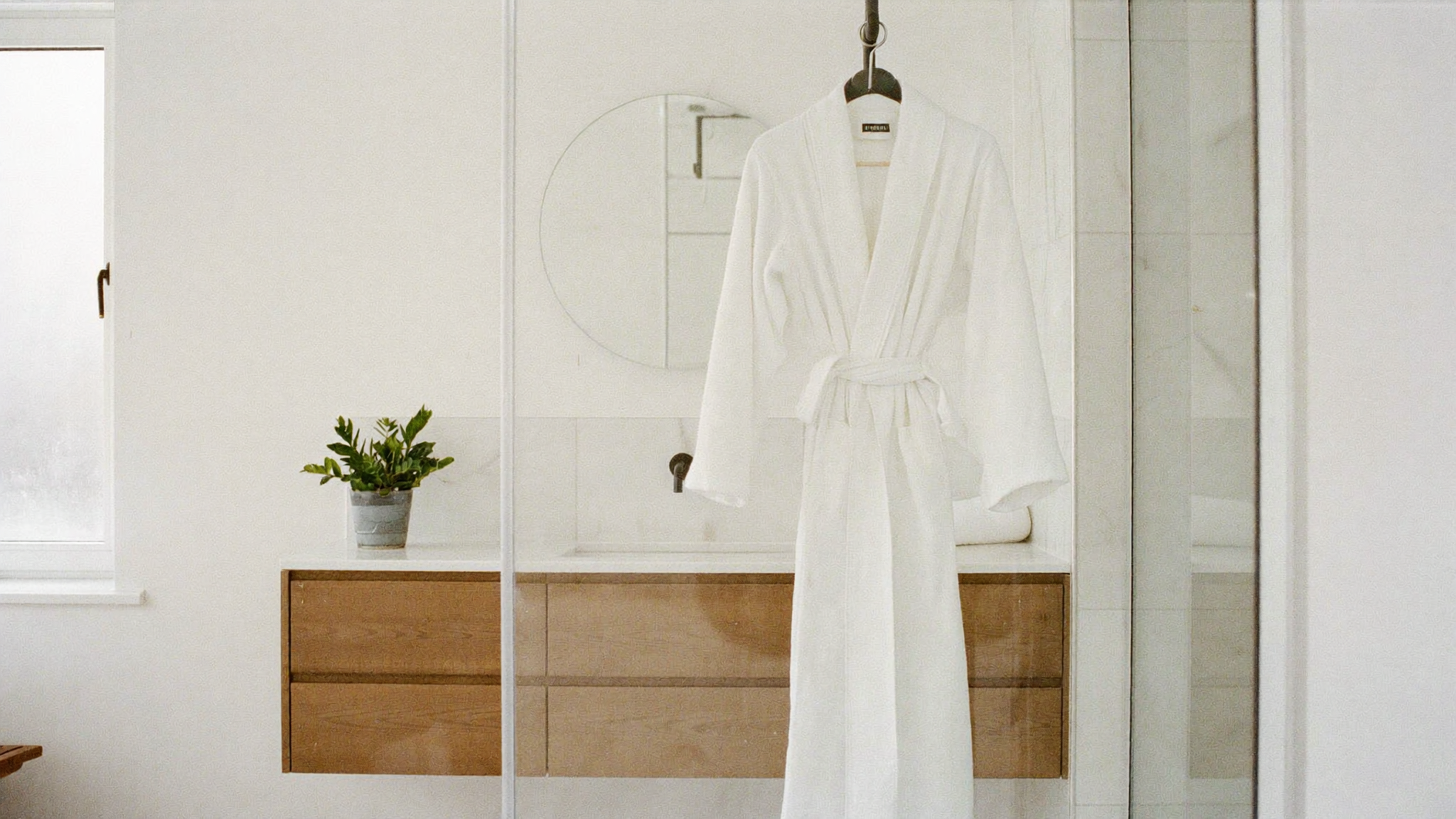 Peignoir suspendu dans une salle de bain lumineuse et épurée