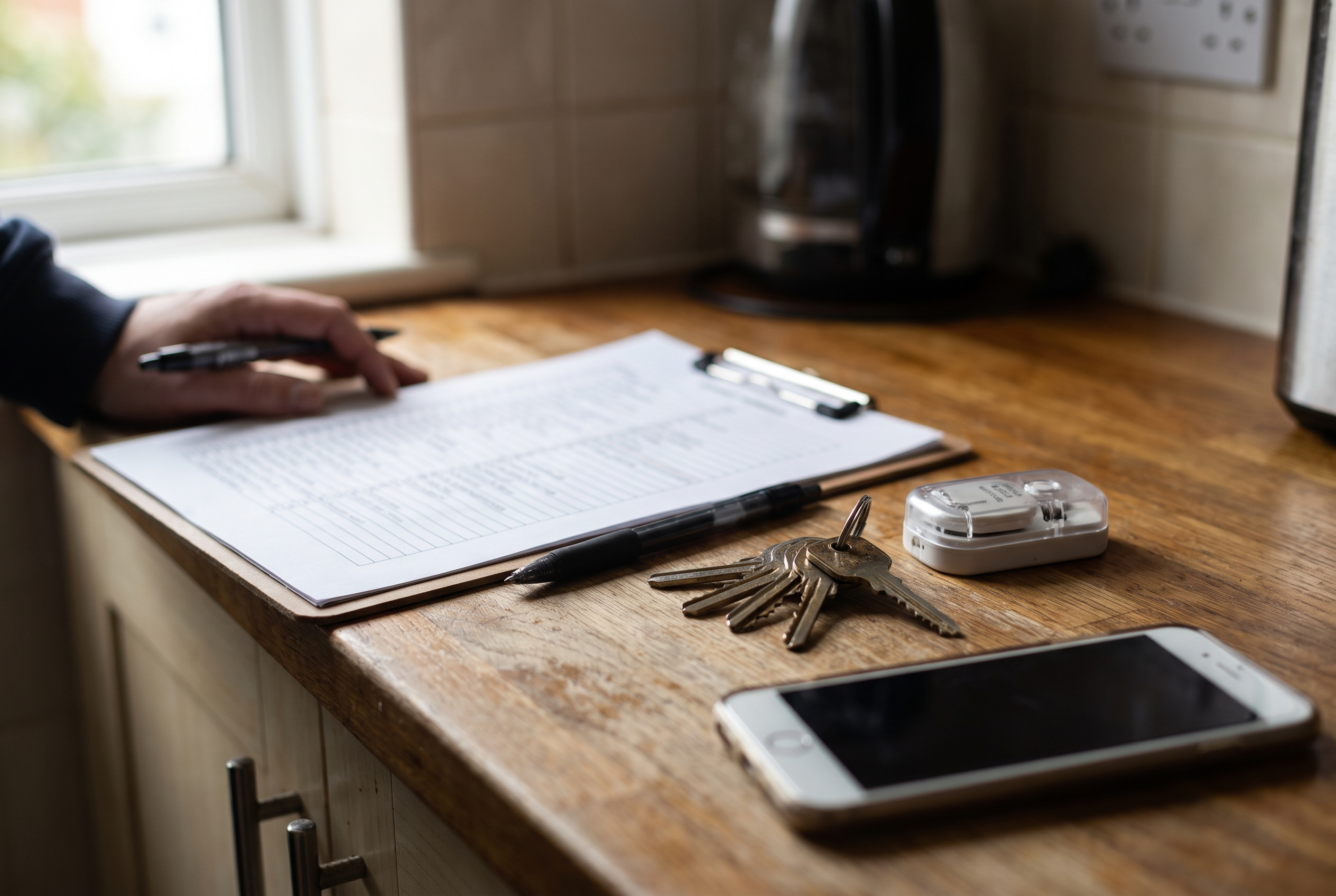 Property inspection checklist and house keys on a kitchen worktop