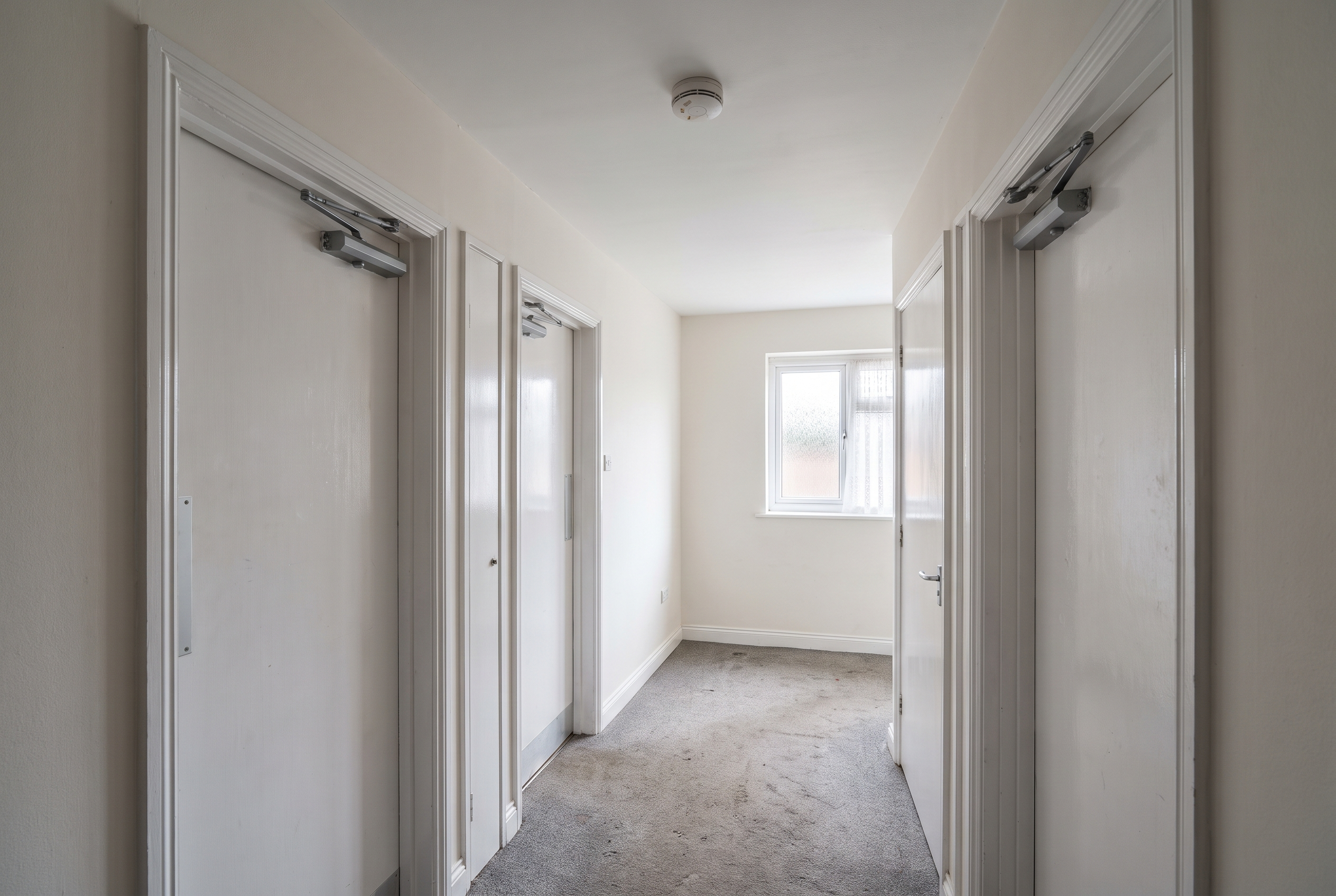 Landing in a shared house with fire doors and a smoke detector