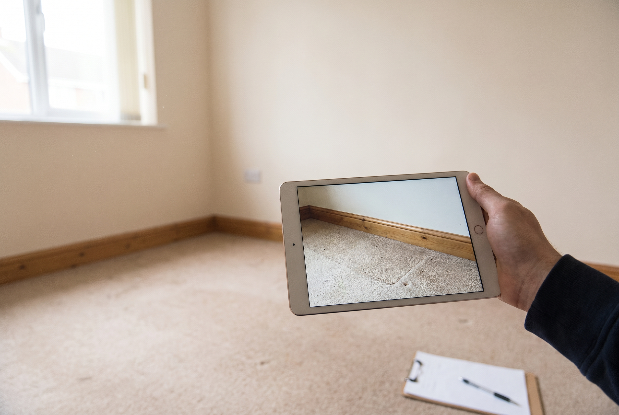 Check-out inventory being photographed on a tablet in an empty flat