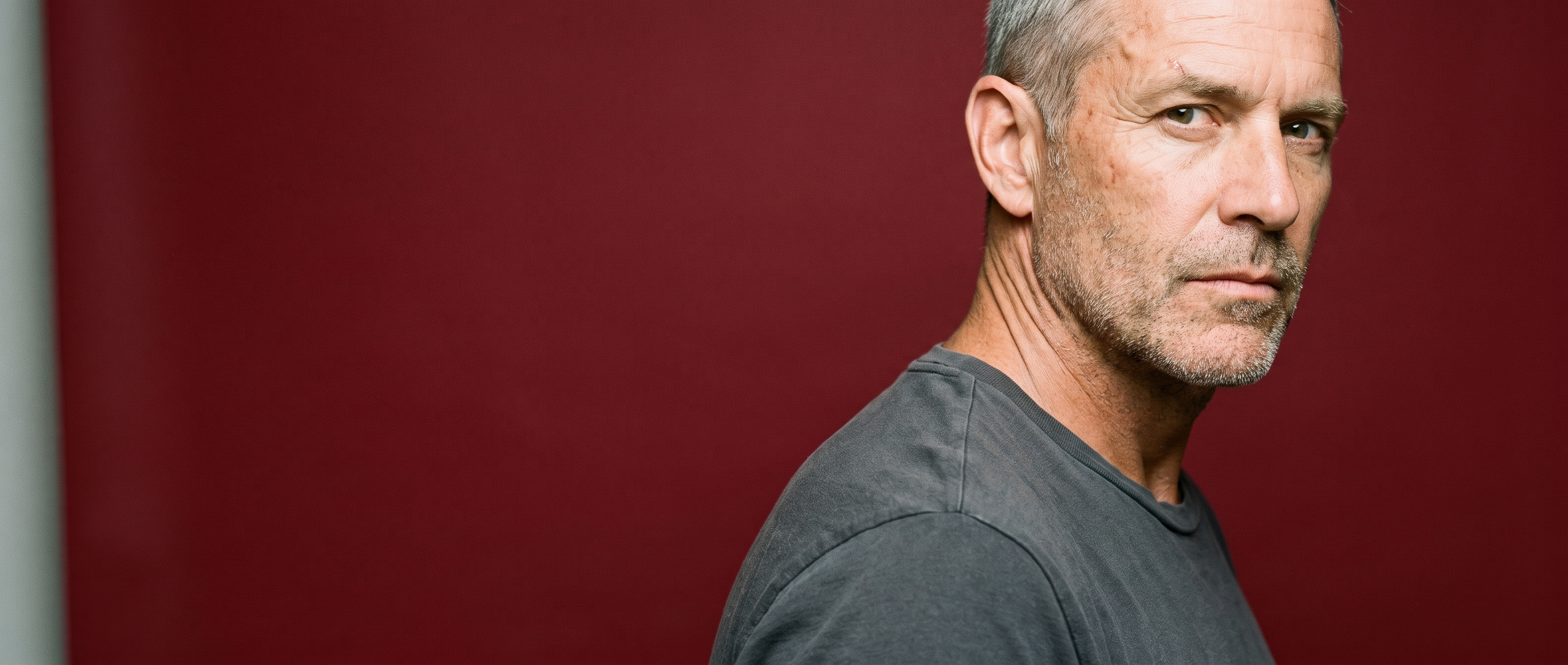 A man in his fifties caught mid-turn against an open oxblood sweep