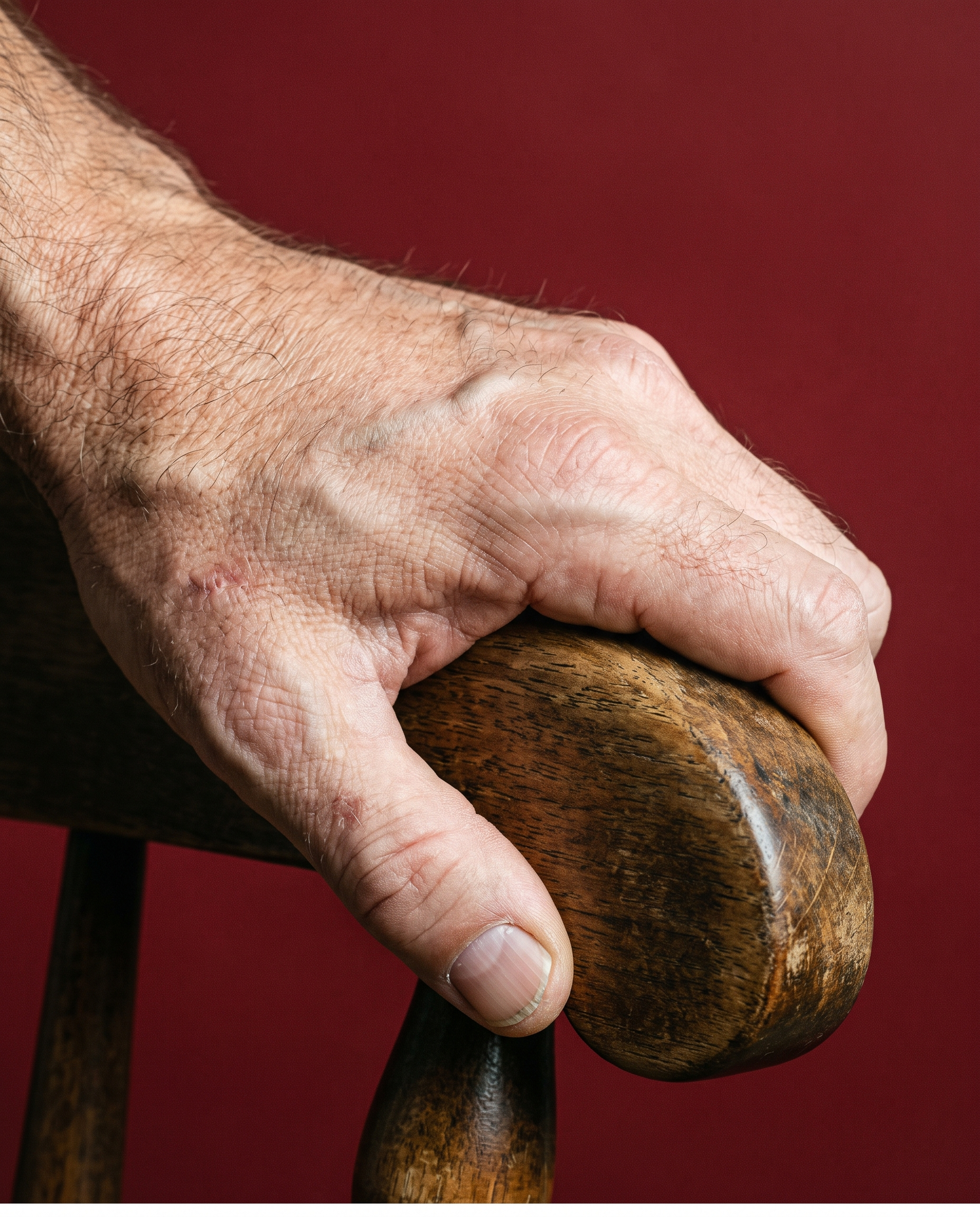 Macro of a hand gripping the arm of a chair