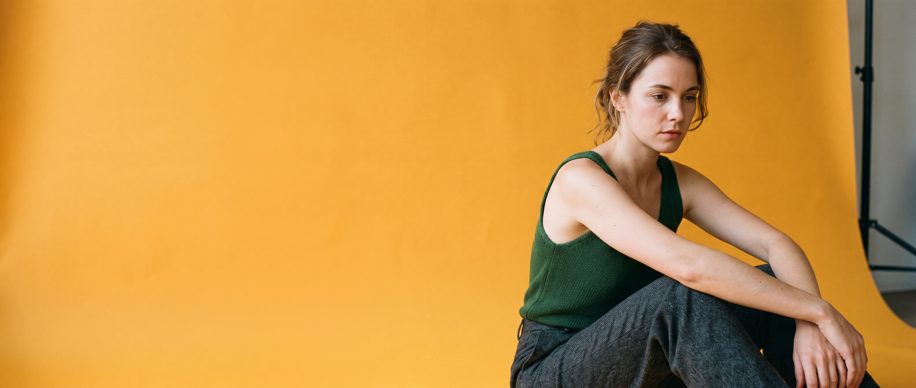 A woman seated at the right of a wide open amber sweep