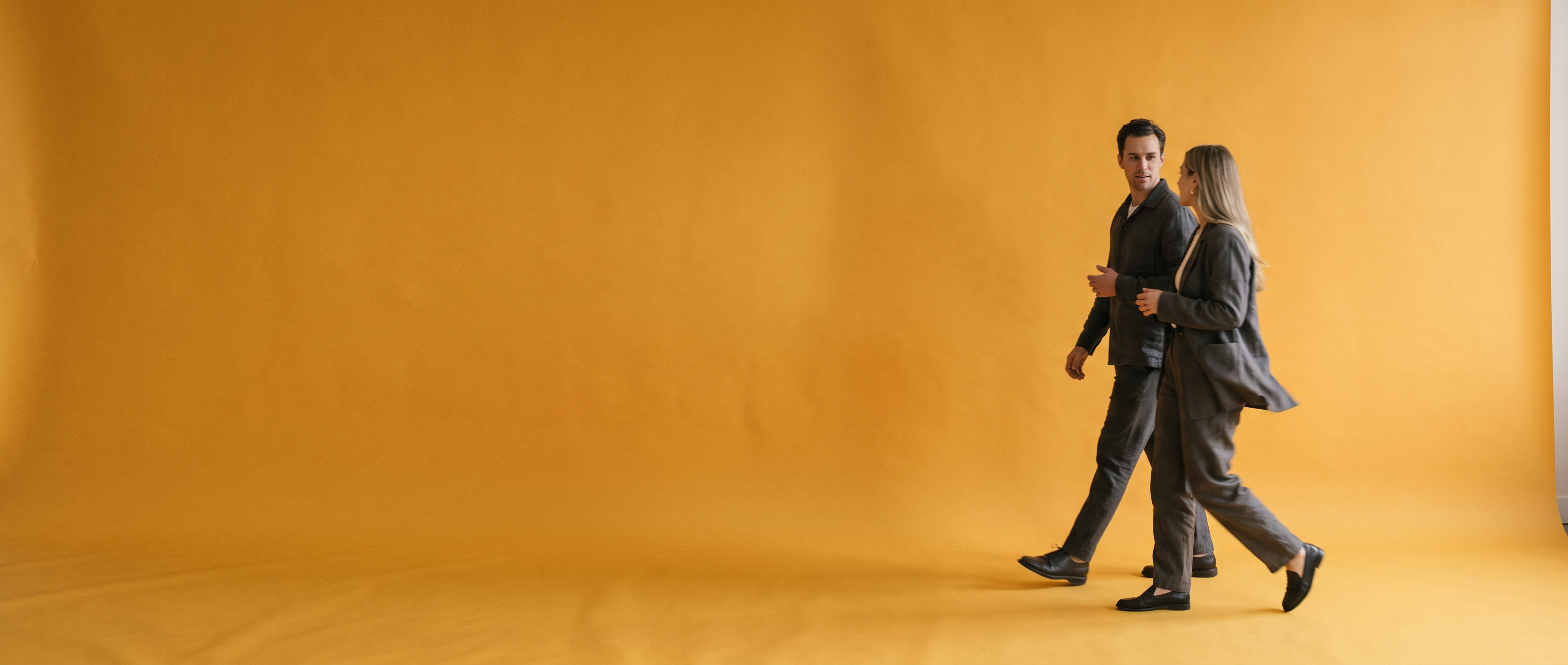 Two people walking across a wide amber sweep, talking