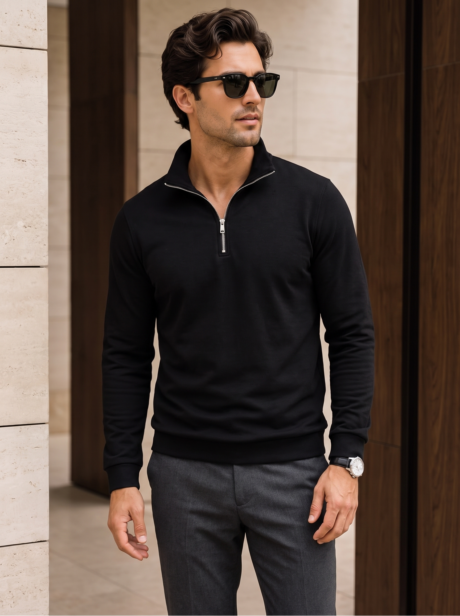Modelo con sudadera negra de cuello alto y media cremallera, combinada con pantalón gris de vestir.