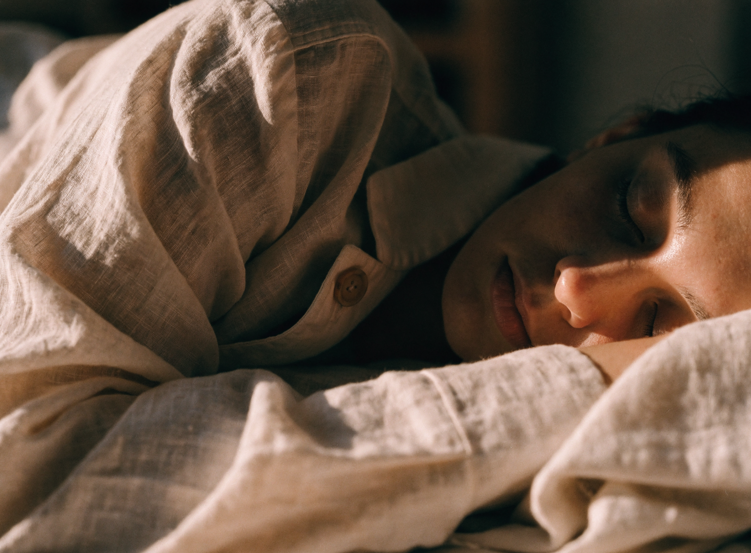 Asleep in linen pyjamas in warm dawn light