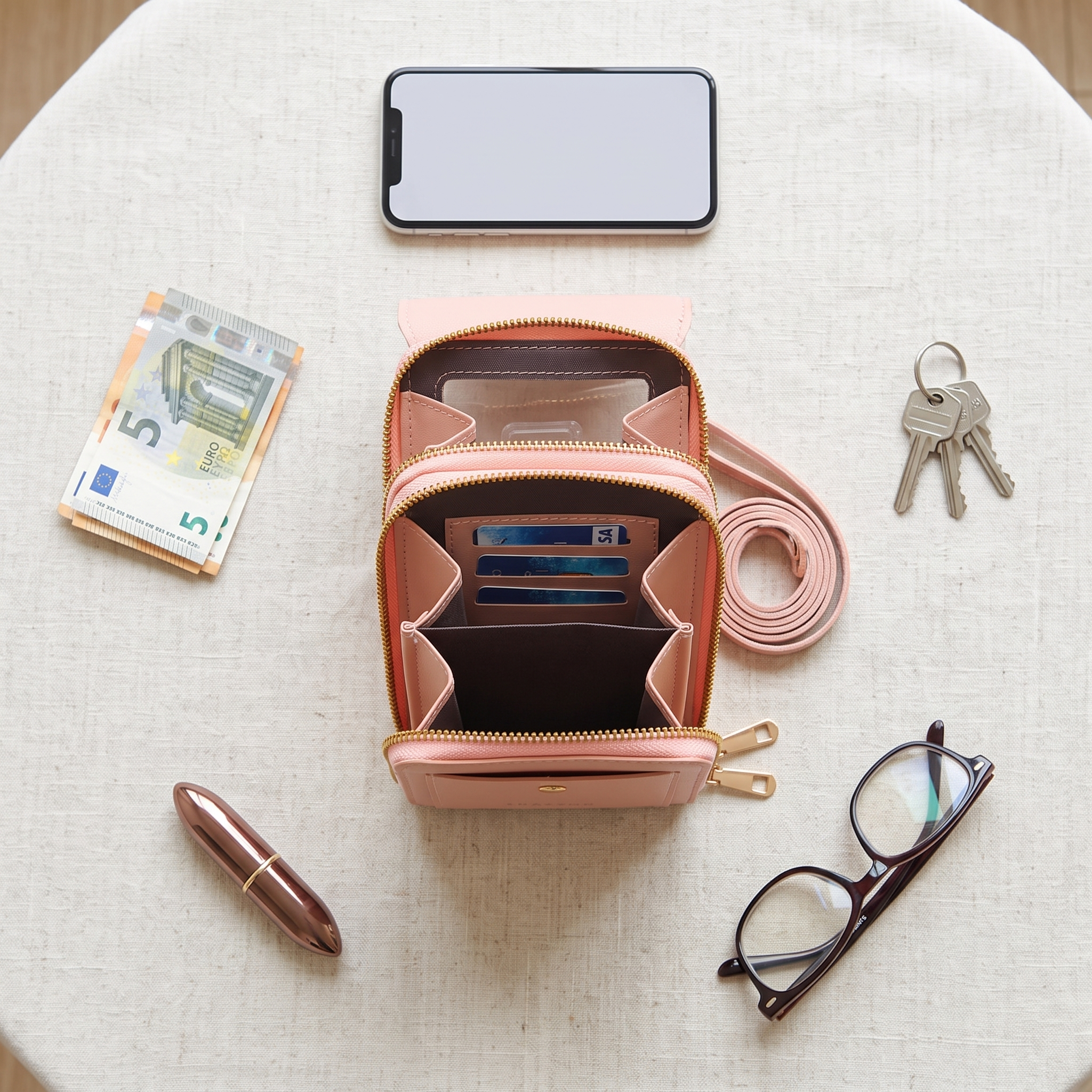 Open Portella met pasjes, telefoon, geld, sleutels en lippenstift ernaast